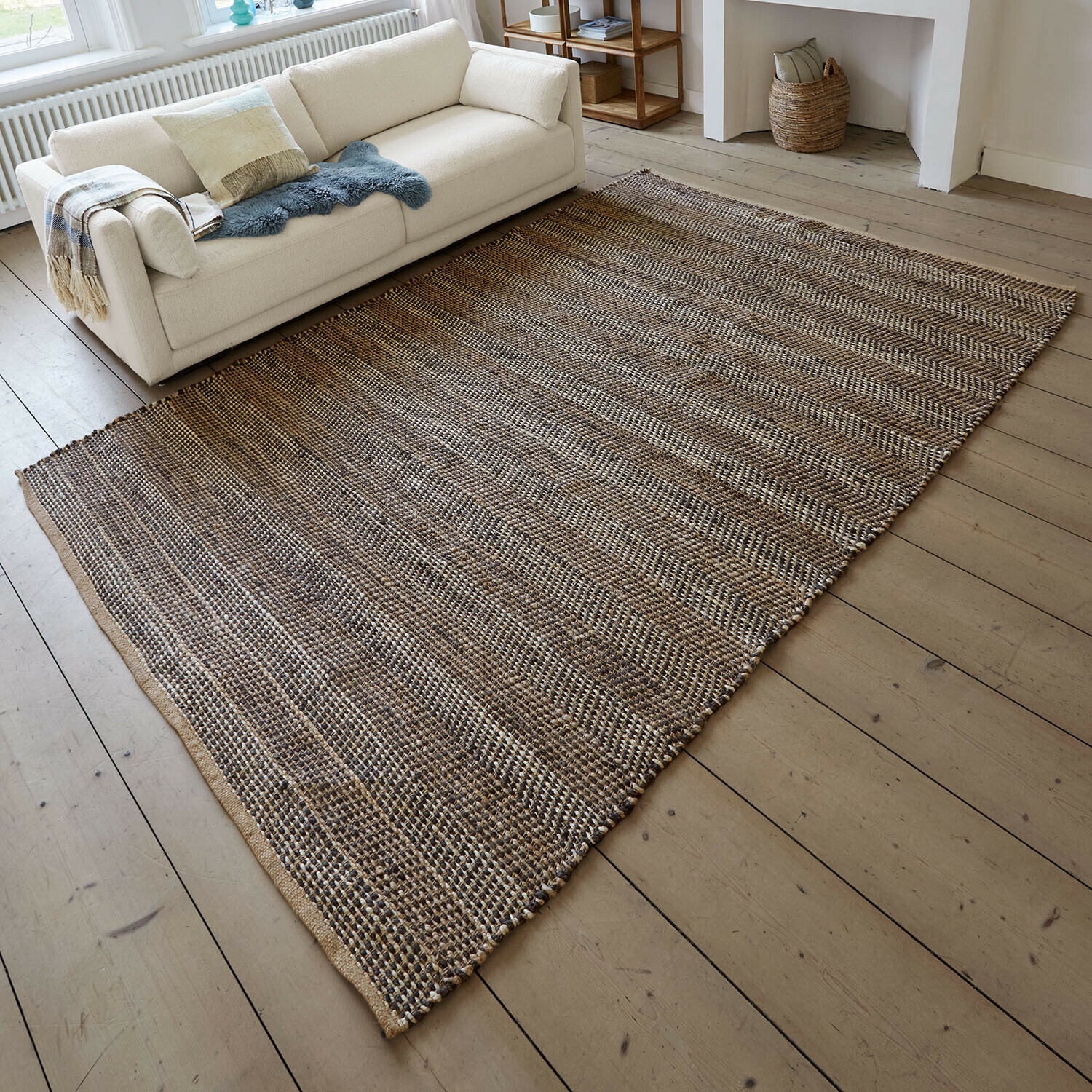 Teppich Myråsen Naturfaser-Teppich in Braun-Beige auf hellem Holzboden neben weißem Sofa im Wohnzimmer