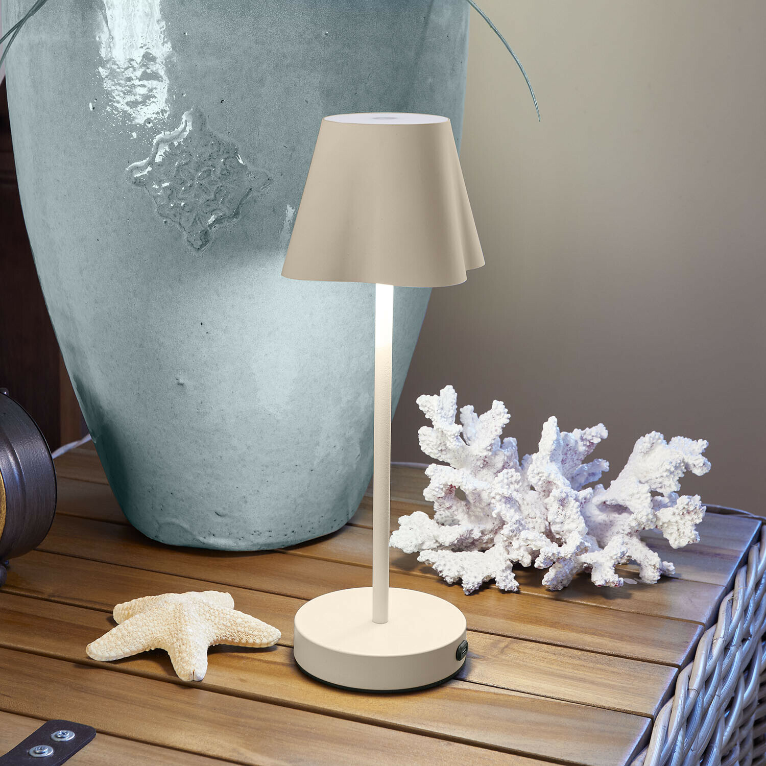 Wiederaufladbare Tischlampe Tenari Beige Metall-Tischlampe auf Holztisch mit maritimer Dekoration und großem Vase