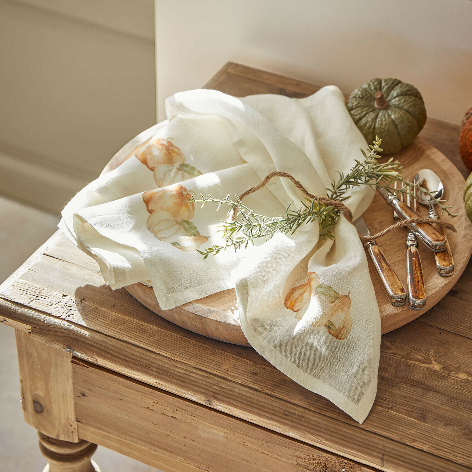 Serviette 4er Set Florrien Leinenserviette in Creme mit Kürbismotiv und Kräuterdekoration auf Holztablett mit Besteck