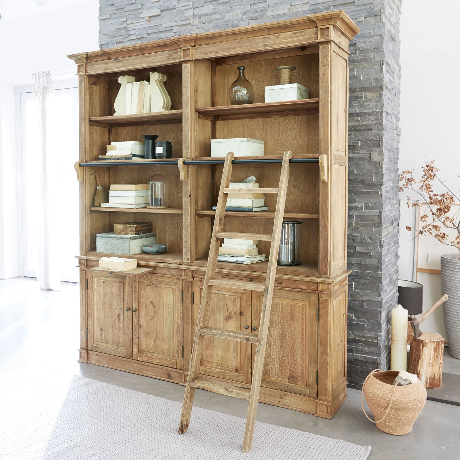 Schrank Livera Großes Bücherregal aus Holz mit Leiter und gefüllten Regalen in hellem Raum