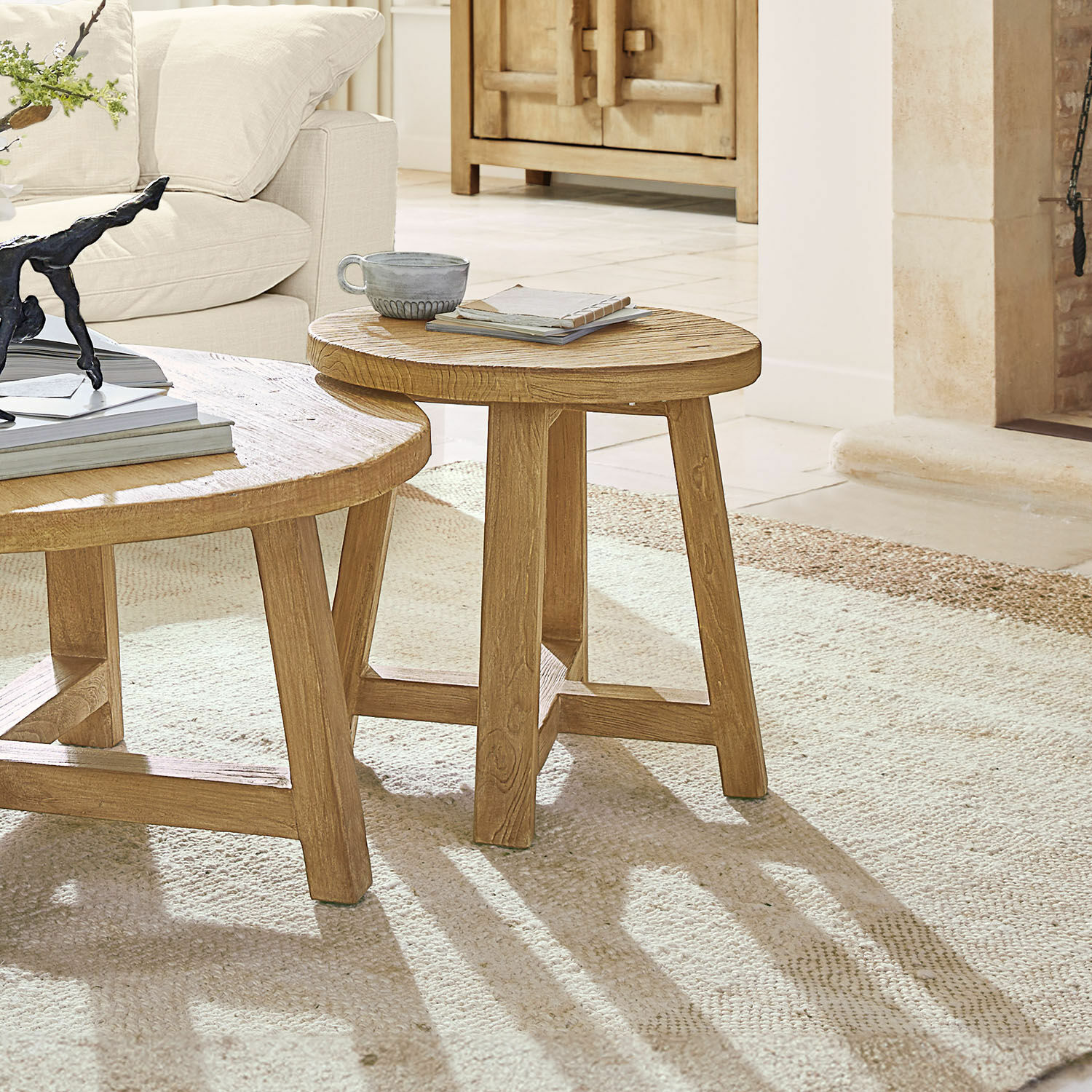Beistelltisch Gorivel Runder Couchtisch aus Holz in Naturfarbe auf hellem Teppich vor beigem Sofa im Wohnzimmer