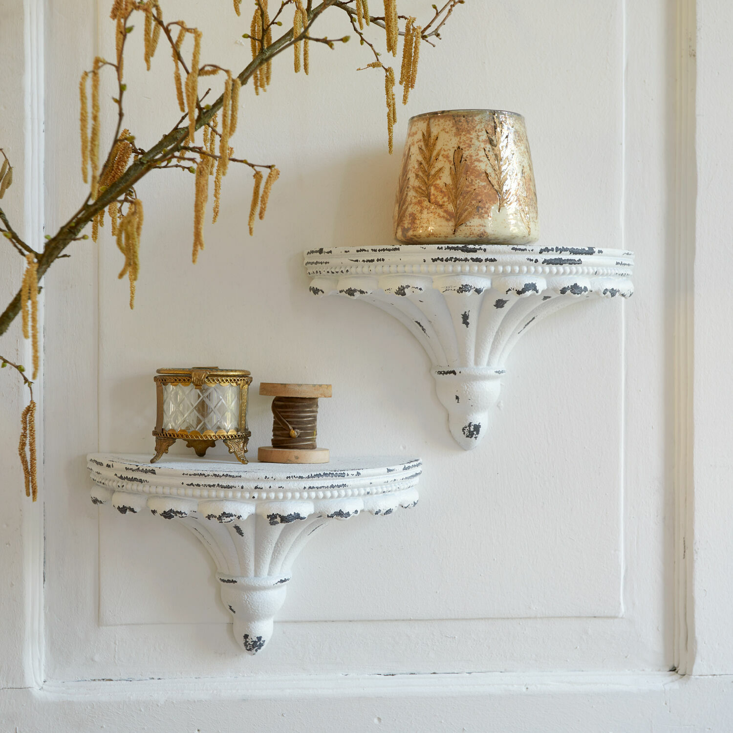 Zwei weiße Wandregale aus antikem Metall mit dekorativen Vintage-Objekten an der Wand