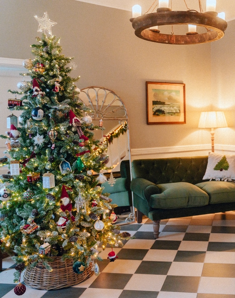 Gemütliches Wohnzimmer mit grünem Sofa und festlich geschmücktem Weihnachtsbaum für Weihnachtsstimmung