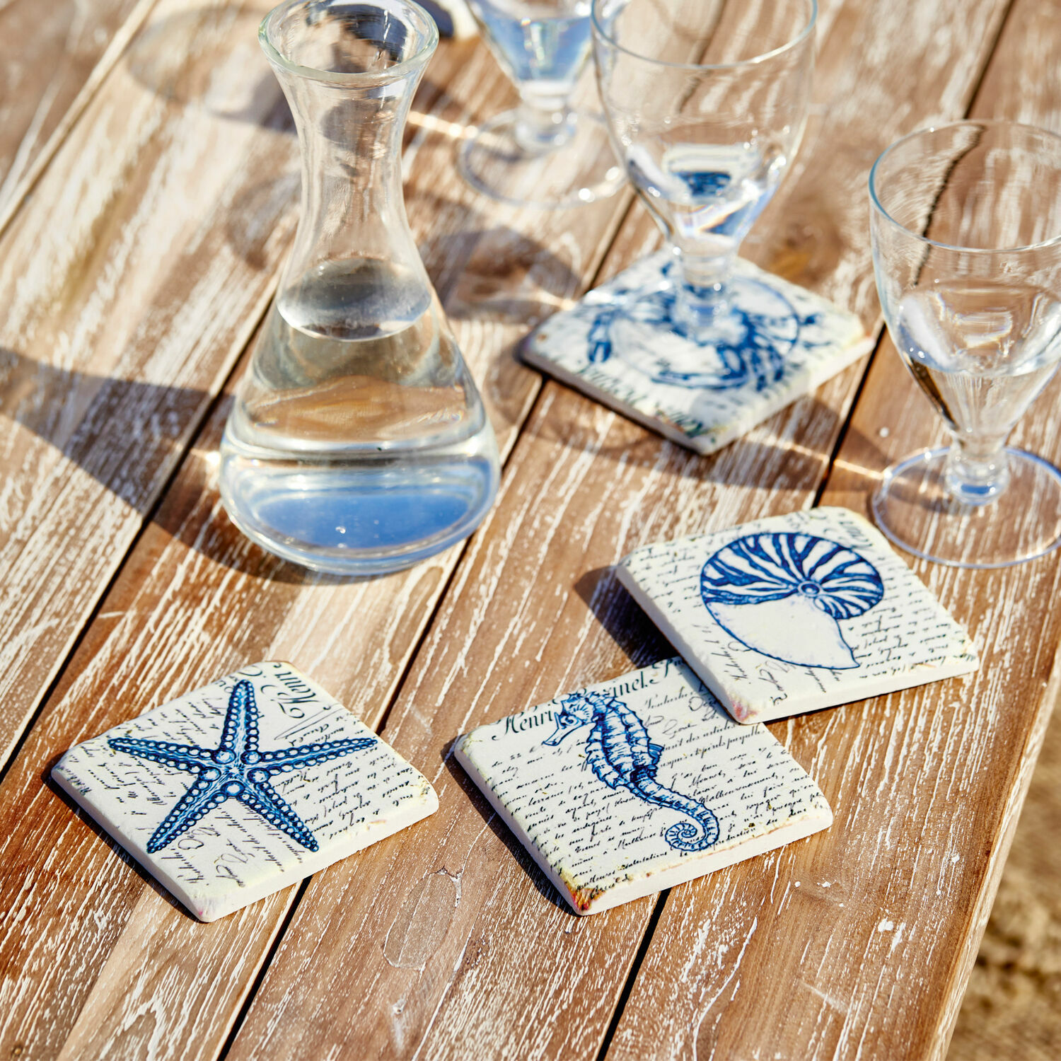 Untersetzer 4er Set Faune Marine Keramik-Untersetzer mit blauen Meeresmotiven auf Holztisch, stilvolle Tischdekoration