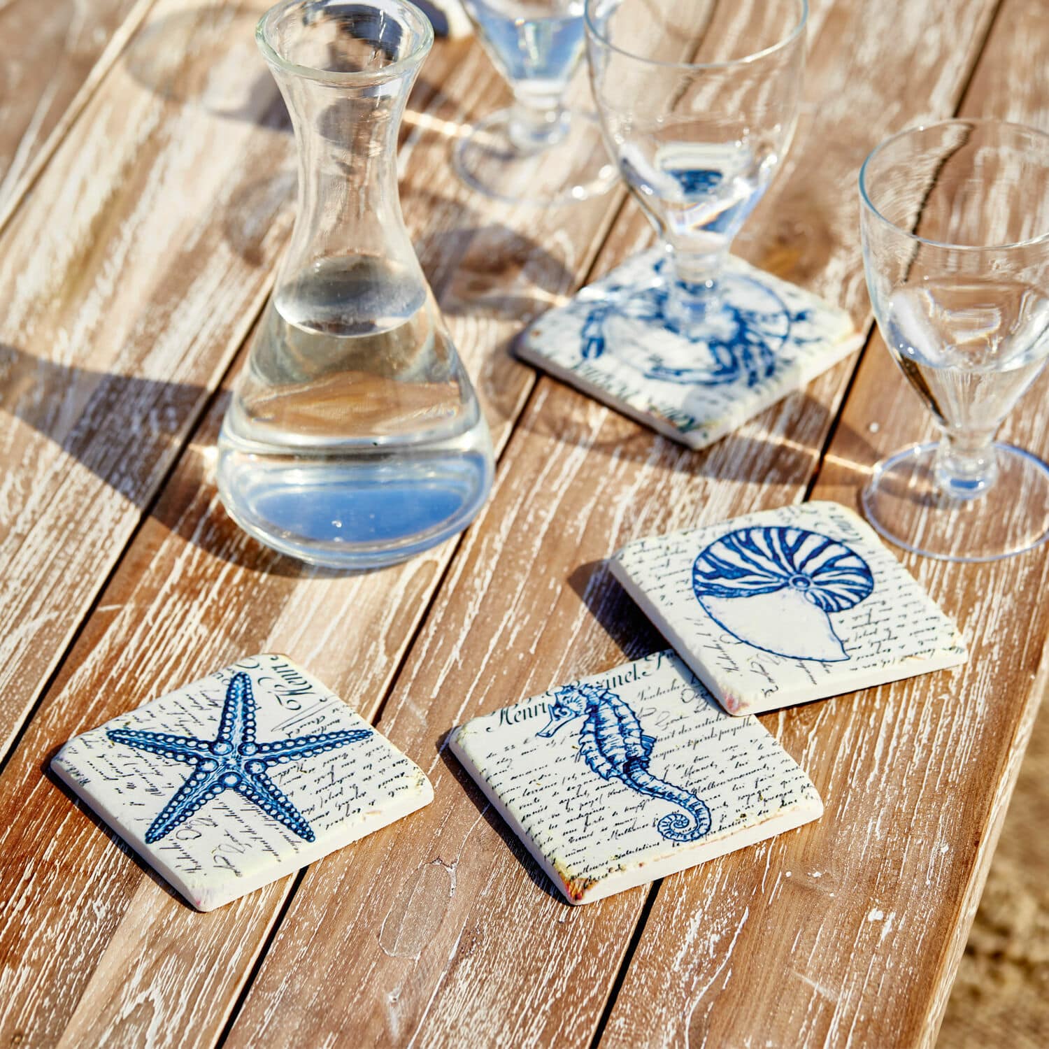 Untersetzer 4er Set Faune Marine Keramik-Untersetzer mit blauen Meeresmotiven auf Holztisch, stilvolle Tischdekoration