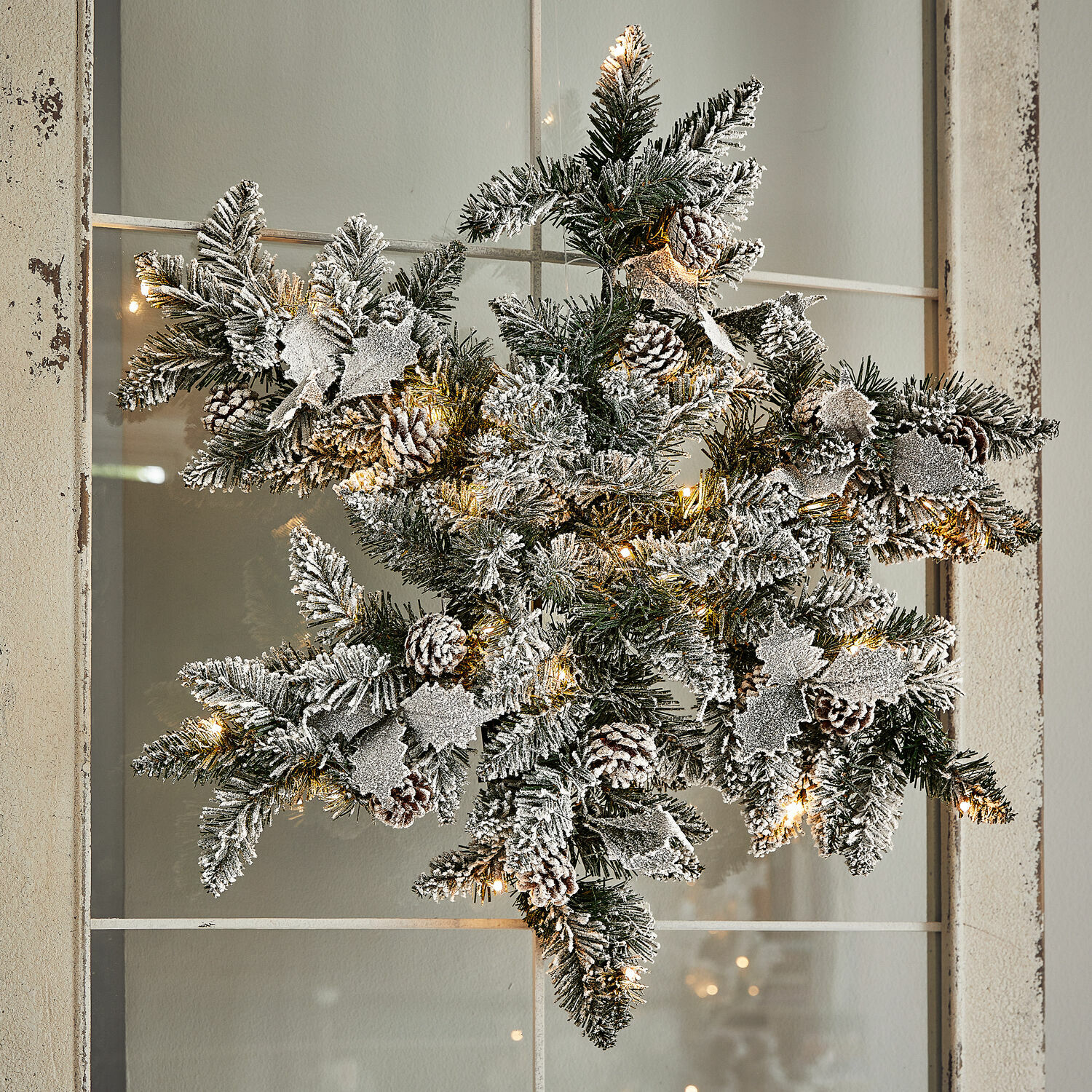 LED-Schneeflocke Azimara Weihnachtsstern aus grünen Zweigen mit Schneeeffekt, Zapfen und warmweißen LED-Lichtern als Deko