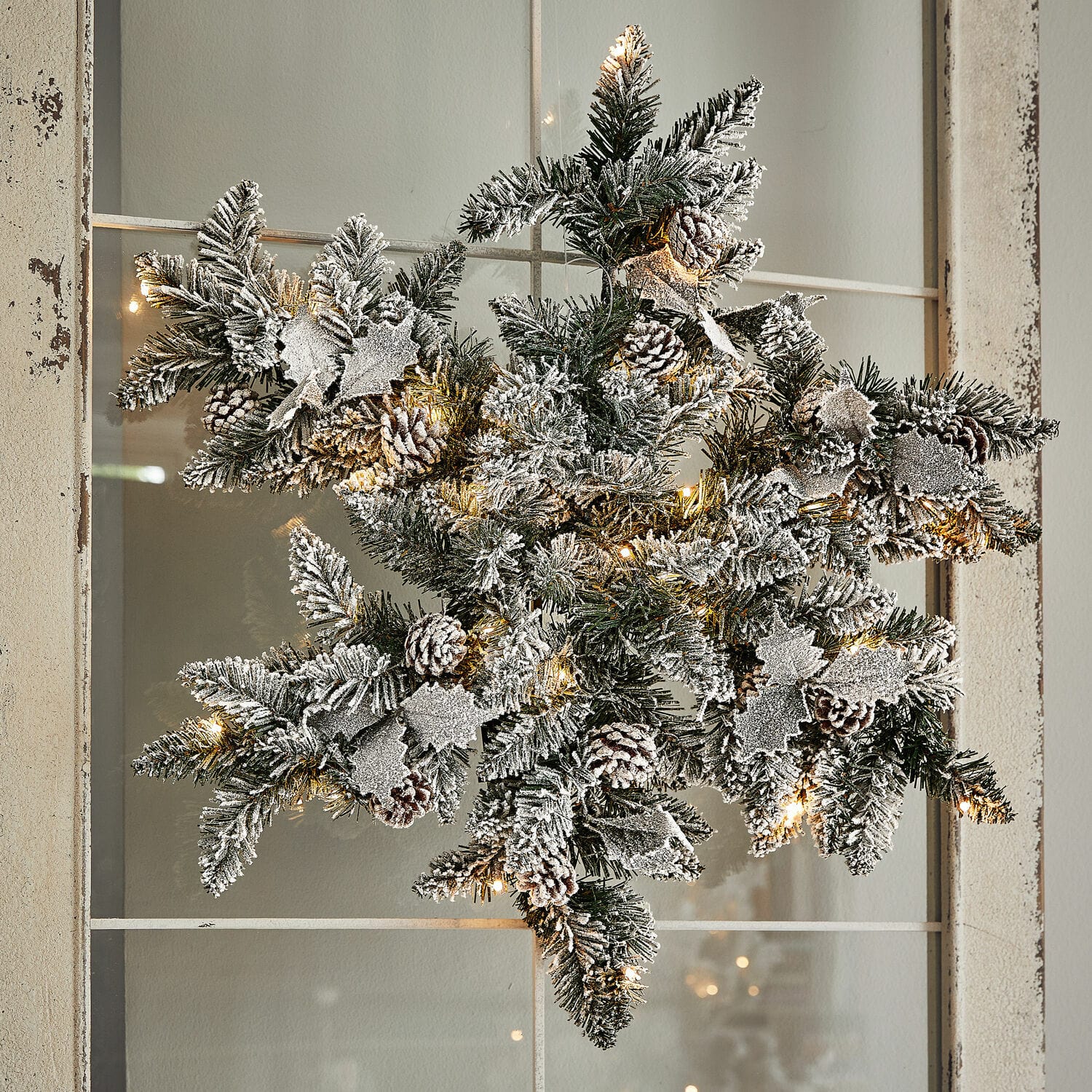 LED-Schneeflocke Azimara Weihnachtsstern aus grünen Zweigen mit Schneeeffekt, Zapfen und warmweißen LED-Lichtern als Deko