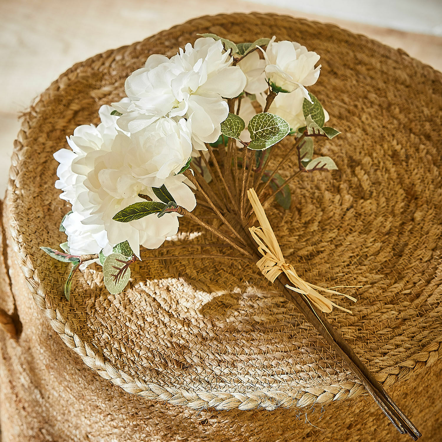 Deko-Blumenstrauß Quérisse Strauß aus weißen künstlichen Blüten mit grünen Blättern auf natürlichem, geflochtenem Juteuntergrund