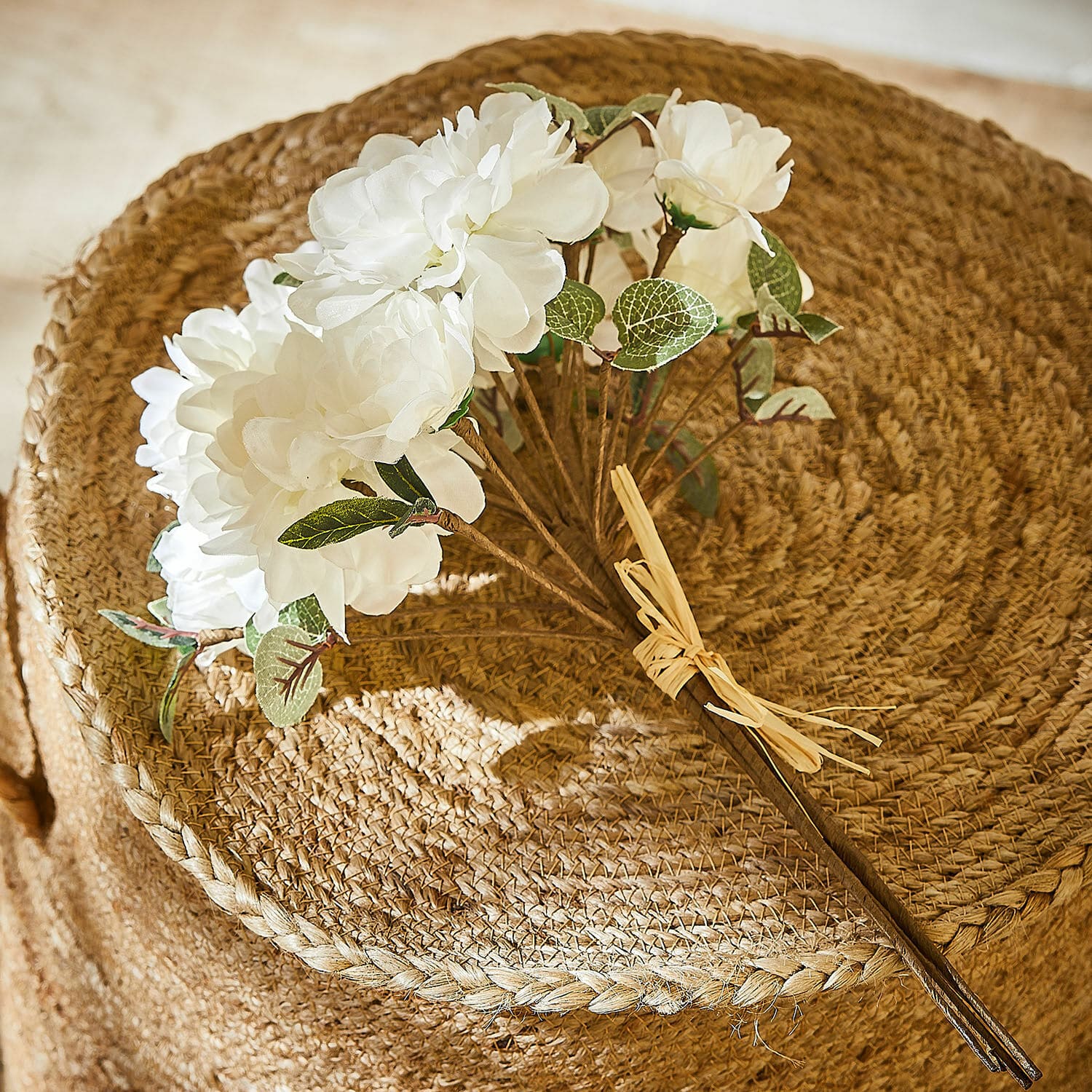 Deko-Blumenstrauß Quérisse Strauß aus weißen künstlichen Blüten mit grünen Blättern auf natürlichem, geflochtenem Juteuntergrund