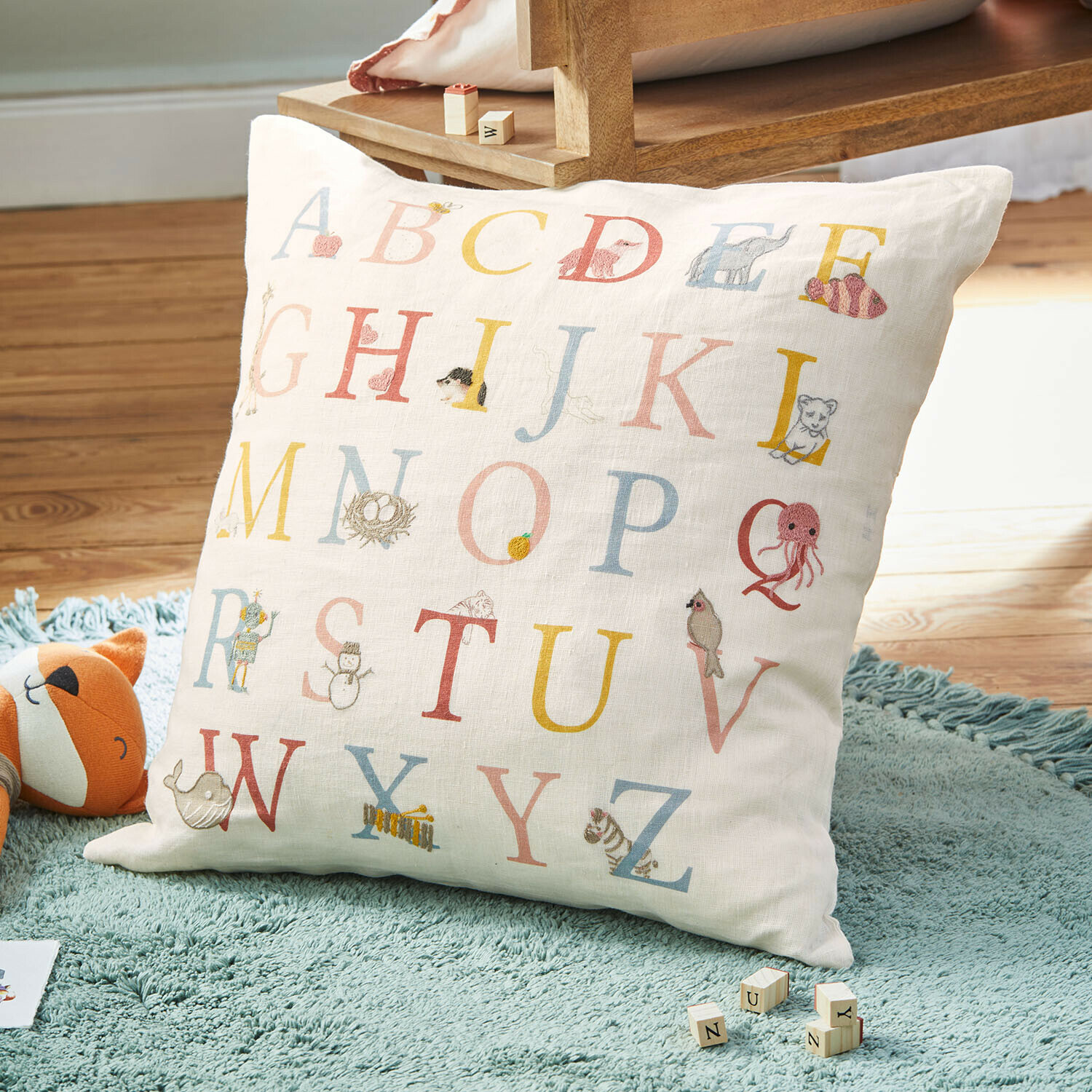Kinderkissen aus weißem Leinen mit buntem Alphabet und Tiermotiven, dekorativ fürs Kinderzimmer