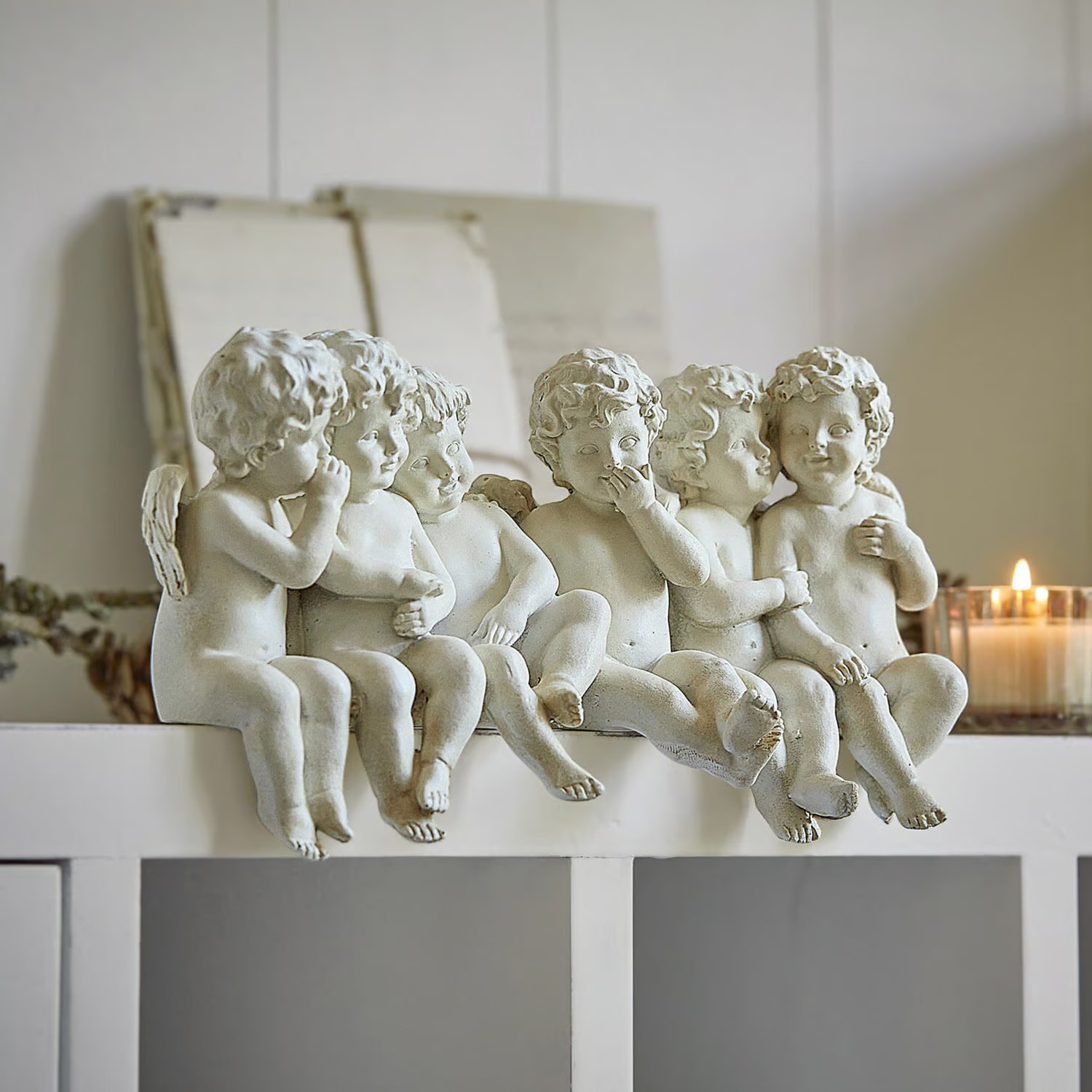 Weiße Engel-Figuren aus Kunststein sitzend auf Regal, dekorative Wohnaccessoires