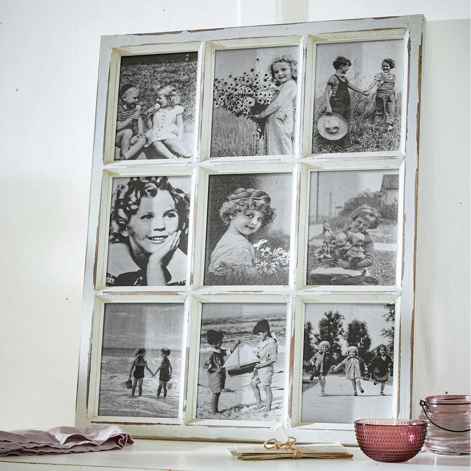 Bilderrahmen Vira Weißer Holzrahmen mit neun schwarz-weißen Vintage-Fotos von Kindern auf einem Tisch