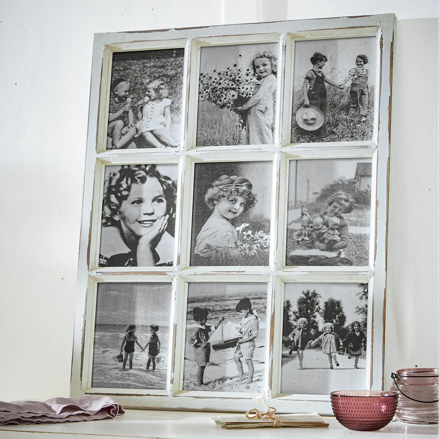 Bilderrahmen Vira Weißer Holzrahmen mit neun schwarz-weißen Vintage-Fotos von Kindern auf einem Tisch