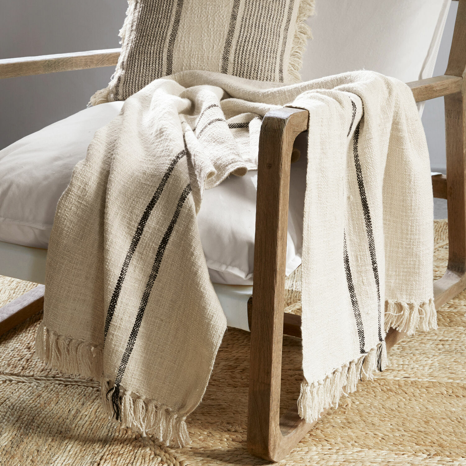 Plaid Toos Beige Baumwollplaid mit schwarzen Streifen und Fransen auf Holzstuhl im Wohnzimmer