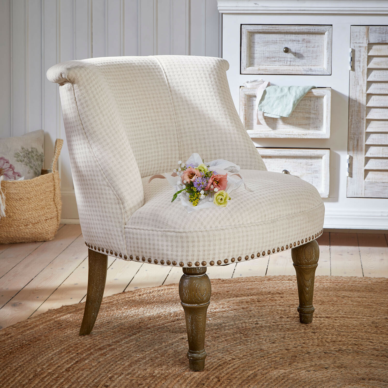 Beiger gepolsterter Sessel mit Holzbeinen auf rundem Teppich im Vintage-Stil