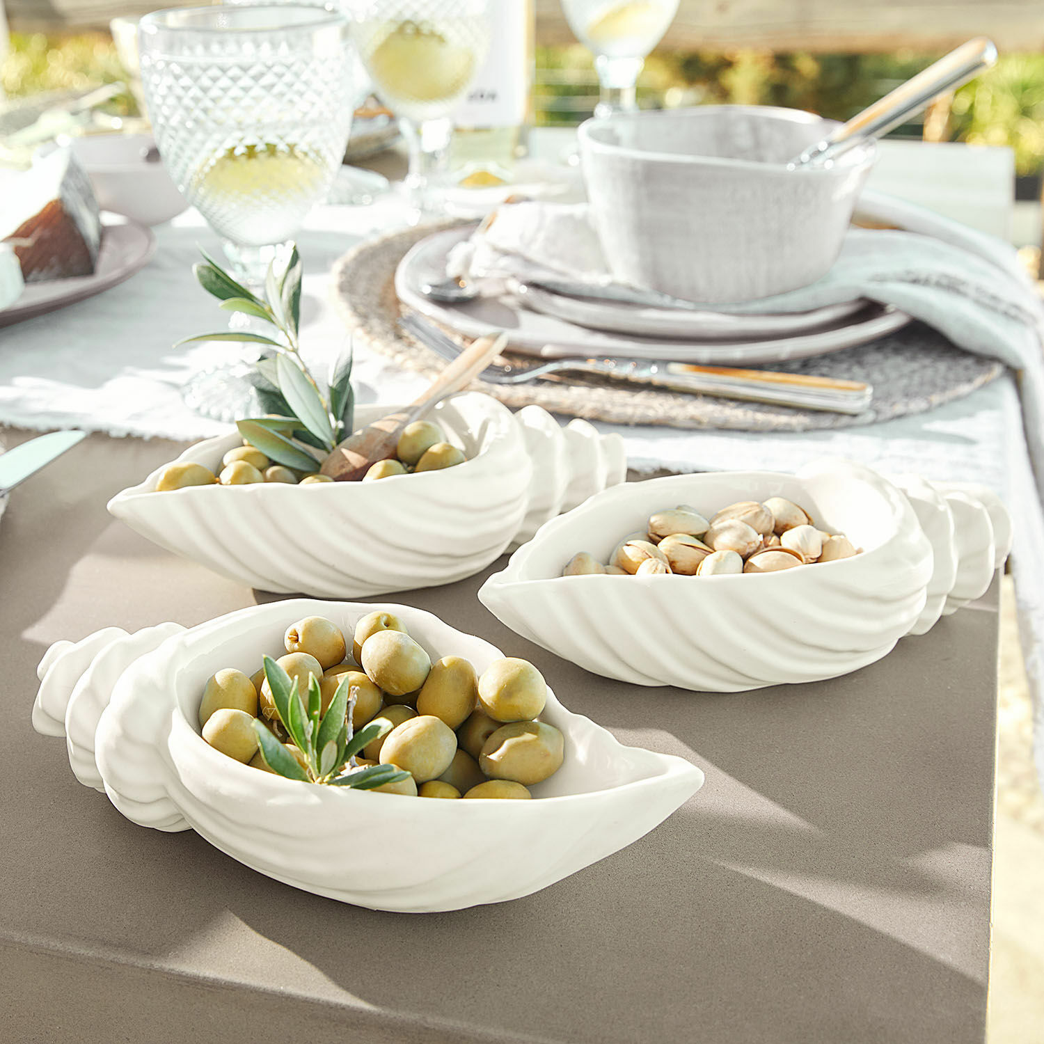 Schale 3er Set Portavin Weiße Keramikschalen in Muschelform mit Oliven und Nüssen auf Gartentisch