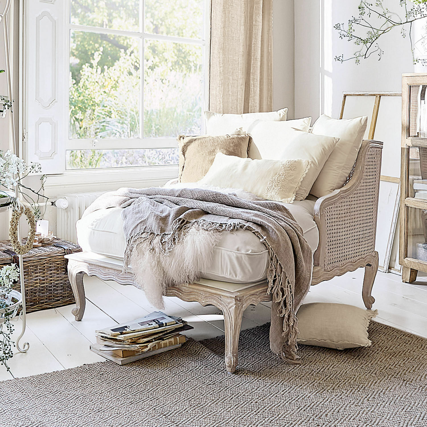 Chaiselongue Dronne Beige Sofa aus Holz und Rattan mit cremefarbenen Kissen und weicher Decke in hellem Raum