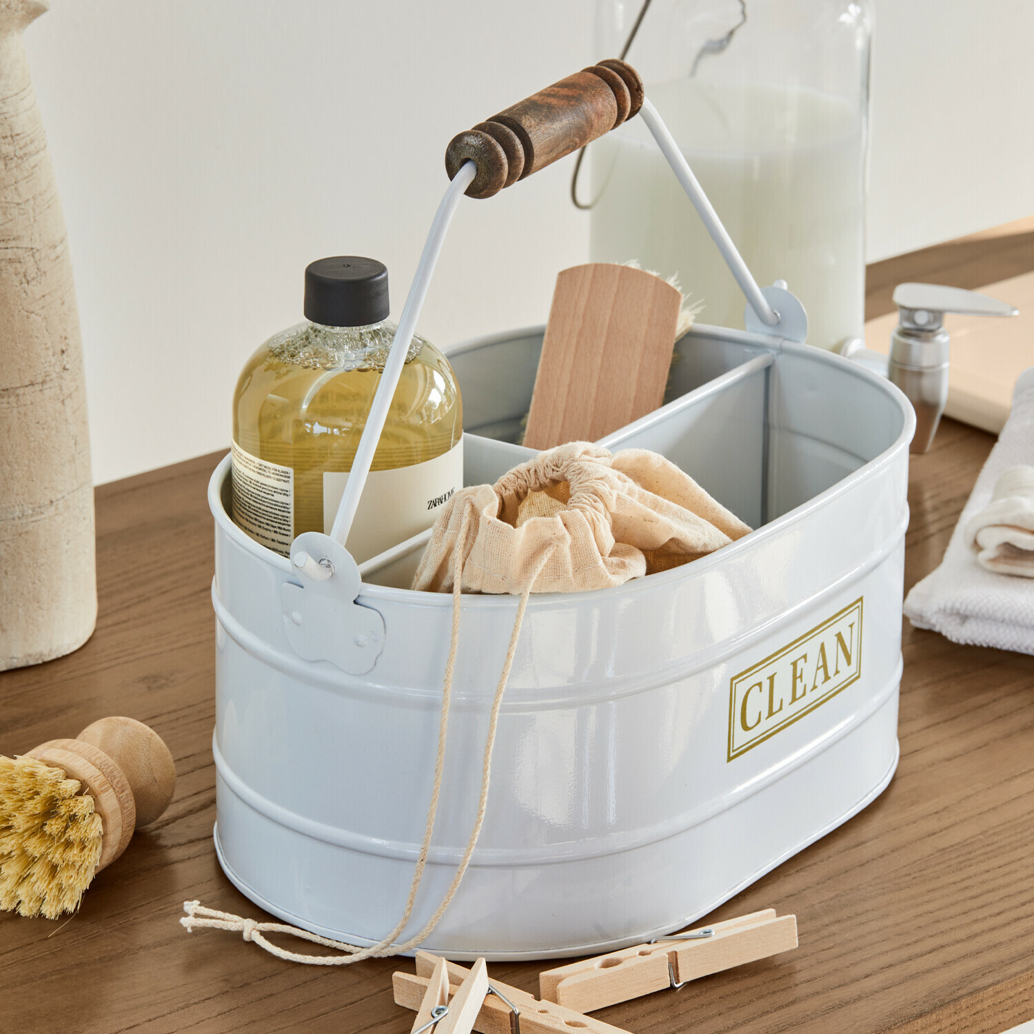 Eimer Clean Weiße Metall-Organizer mit Holzgriff und Aufschrift CLEAN, gefüllt mit Reinigungsutensilien