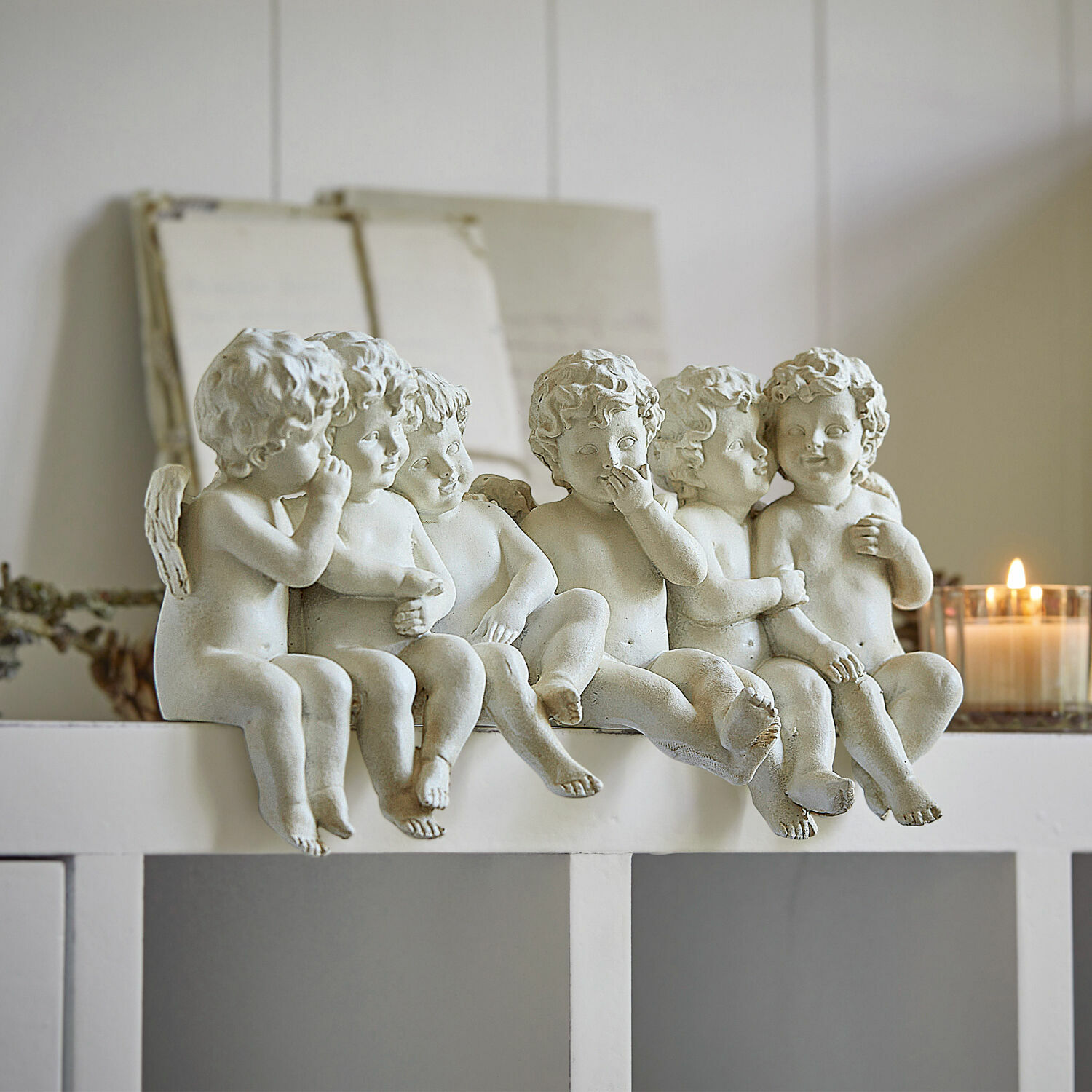Engel Léon Sechs weiße Engel-Figuren aus Kunststoff auf weißem Regal, dekorative Wohnaccessoires