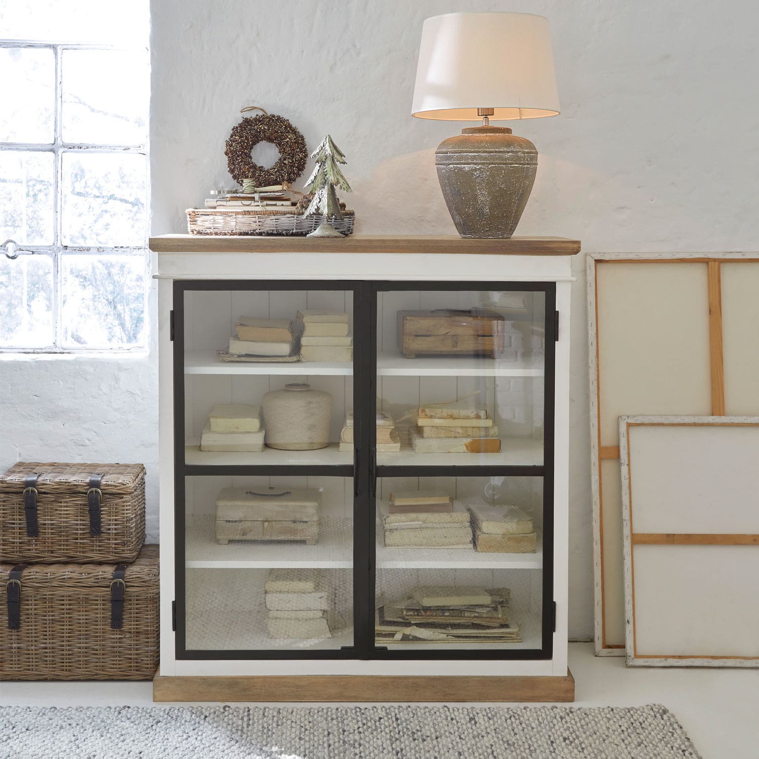 Kommode Mira Weiße Holzvitrine mit Glastüren und Keramiklampe im Vintage-Stil auf der Ablage