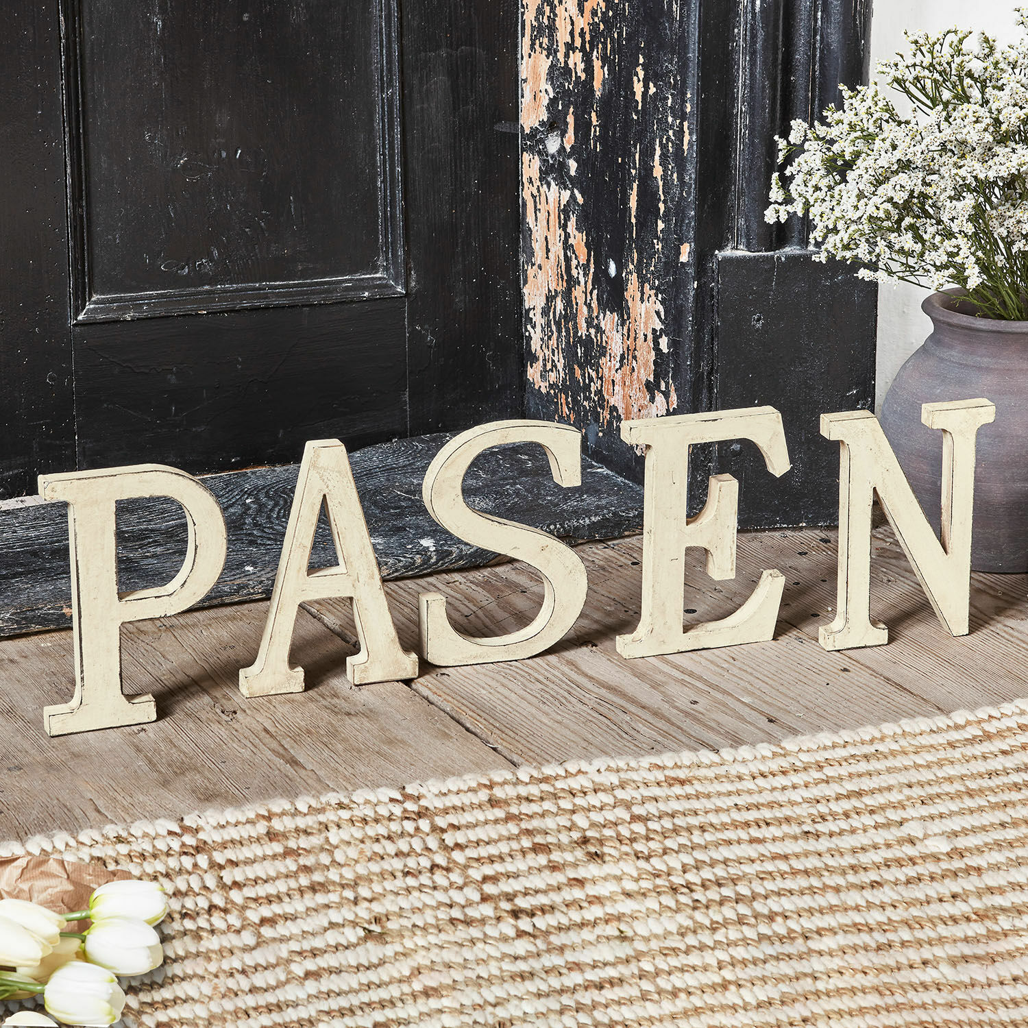 Deko-Buchstaben PASEN Dekorative cremefarbene Holzbuchstaben bilden das Wort PASEN auf rustikalem Holzboden