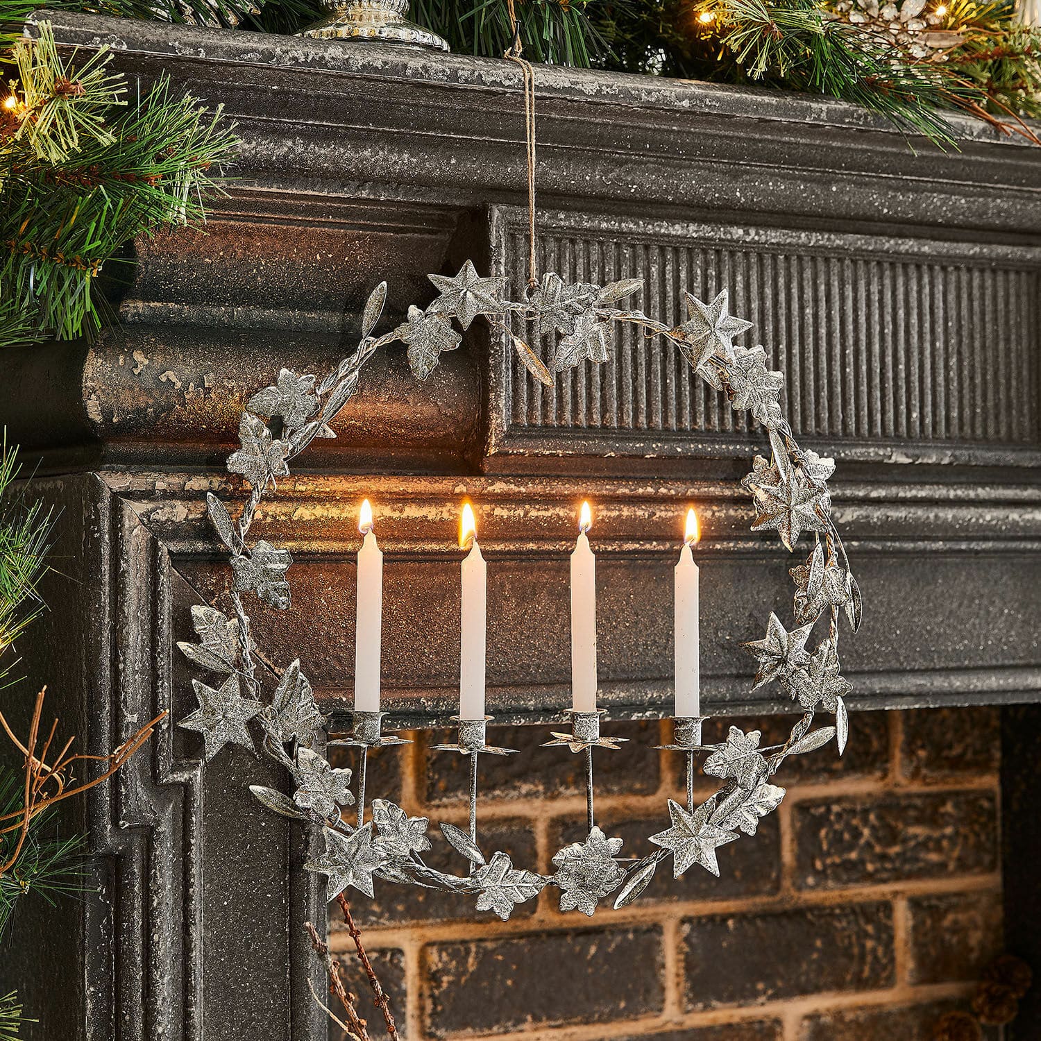 Kerzenhalter Jolvent Metallkranz mit weißen Kerzen und sternförmigen Verzierungen am Kamin, festliche Weihnachtsdekoration