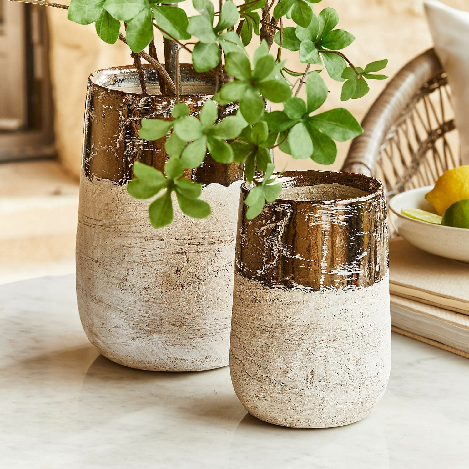 Vase 2er Set Hafira Zwei beige-braune Keramikvasen auf Marmorplatte mit grünen Blättern dekoriert