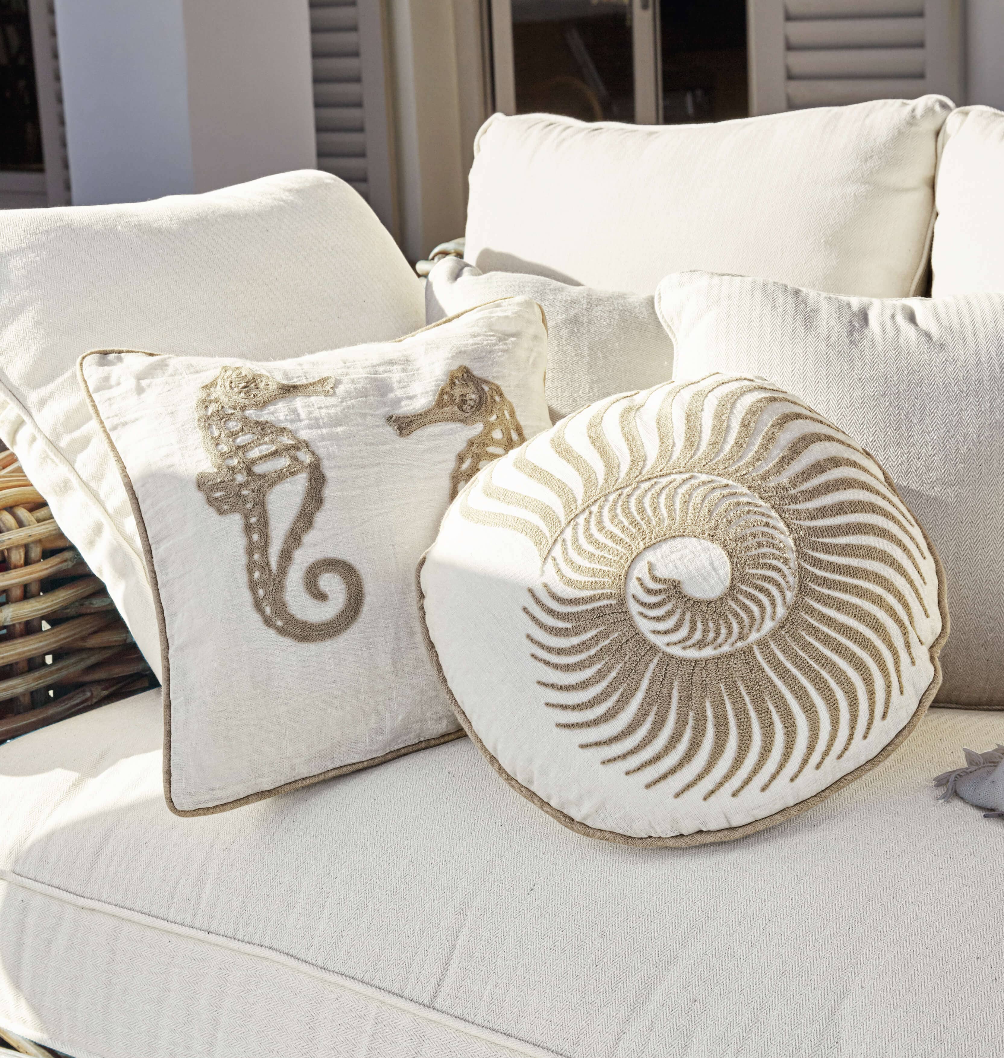 Beige Dekokissen mit maritimen Motiven auf hellem Sofa, Wohntextilien