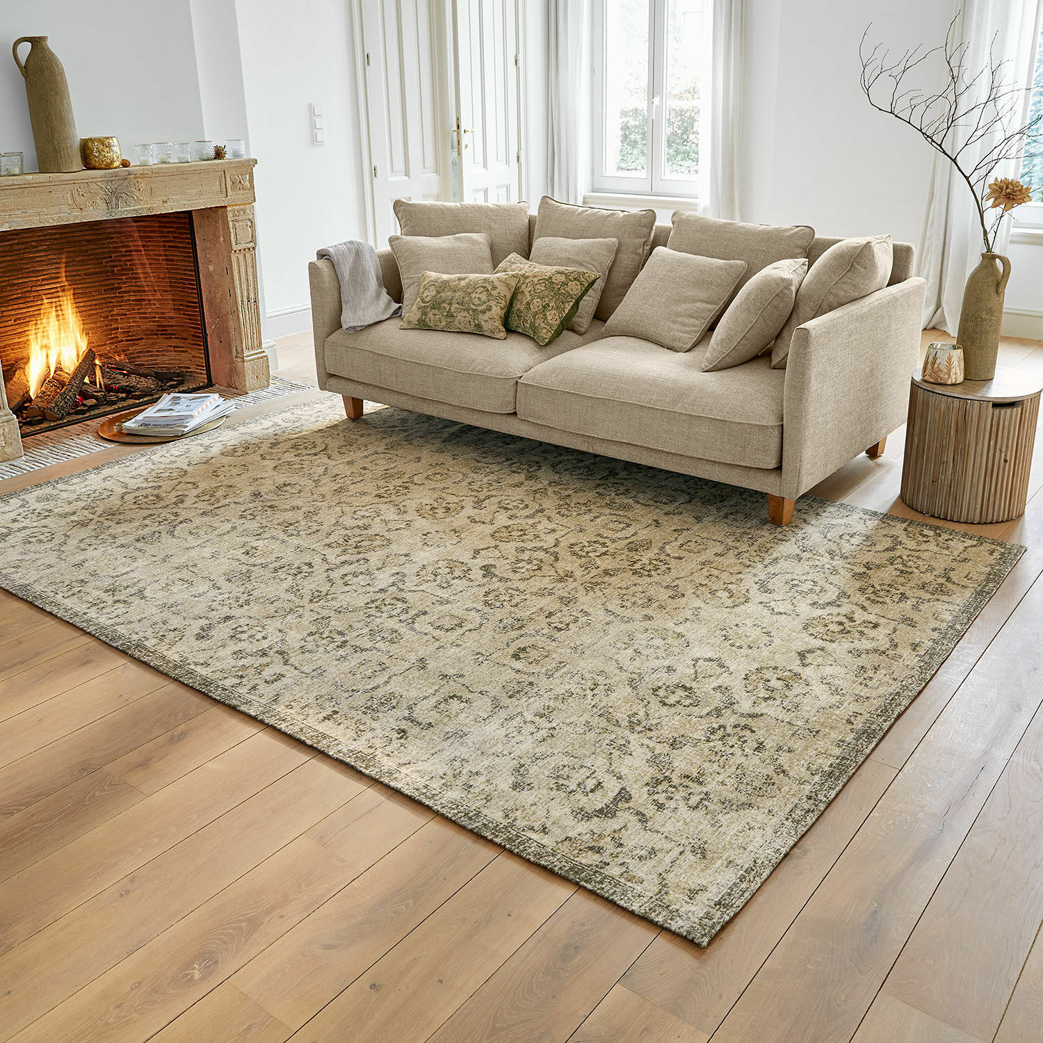 Beigefarbener Teppich mit feinem Muster auf Holzboden im Wohnzimmer mit Sofa und Kamin