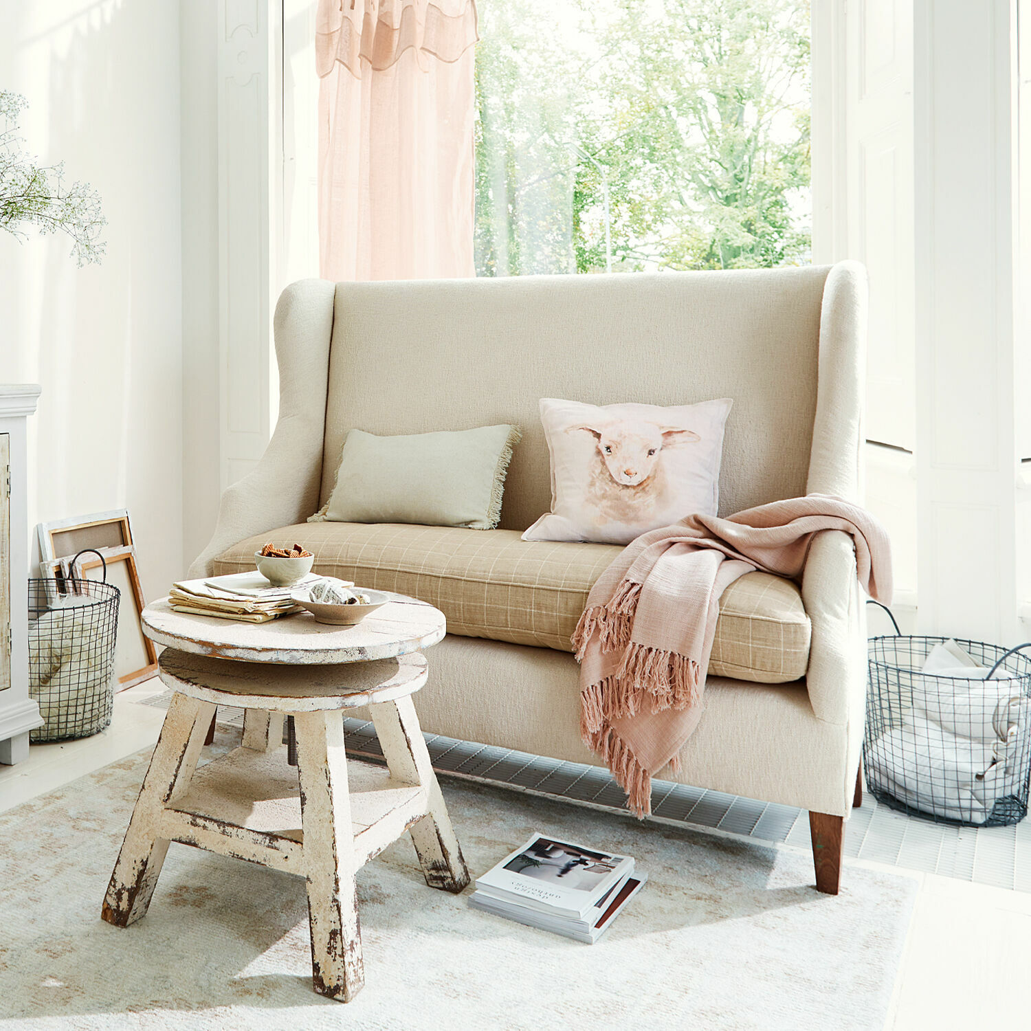 Sofa Ombra Beiges Stoffsofa mit Lamm-Motivkissen und rustikalem Holzcouchtisch in hellem Wohnzimmer
