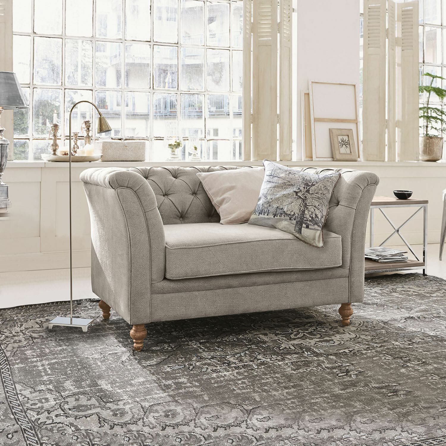 Sofa Clères Grau gepolstertes Sofa mit Holzbeinen auf gemustertem Teppich in hellem Wohnzimmer