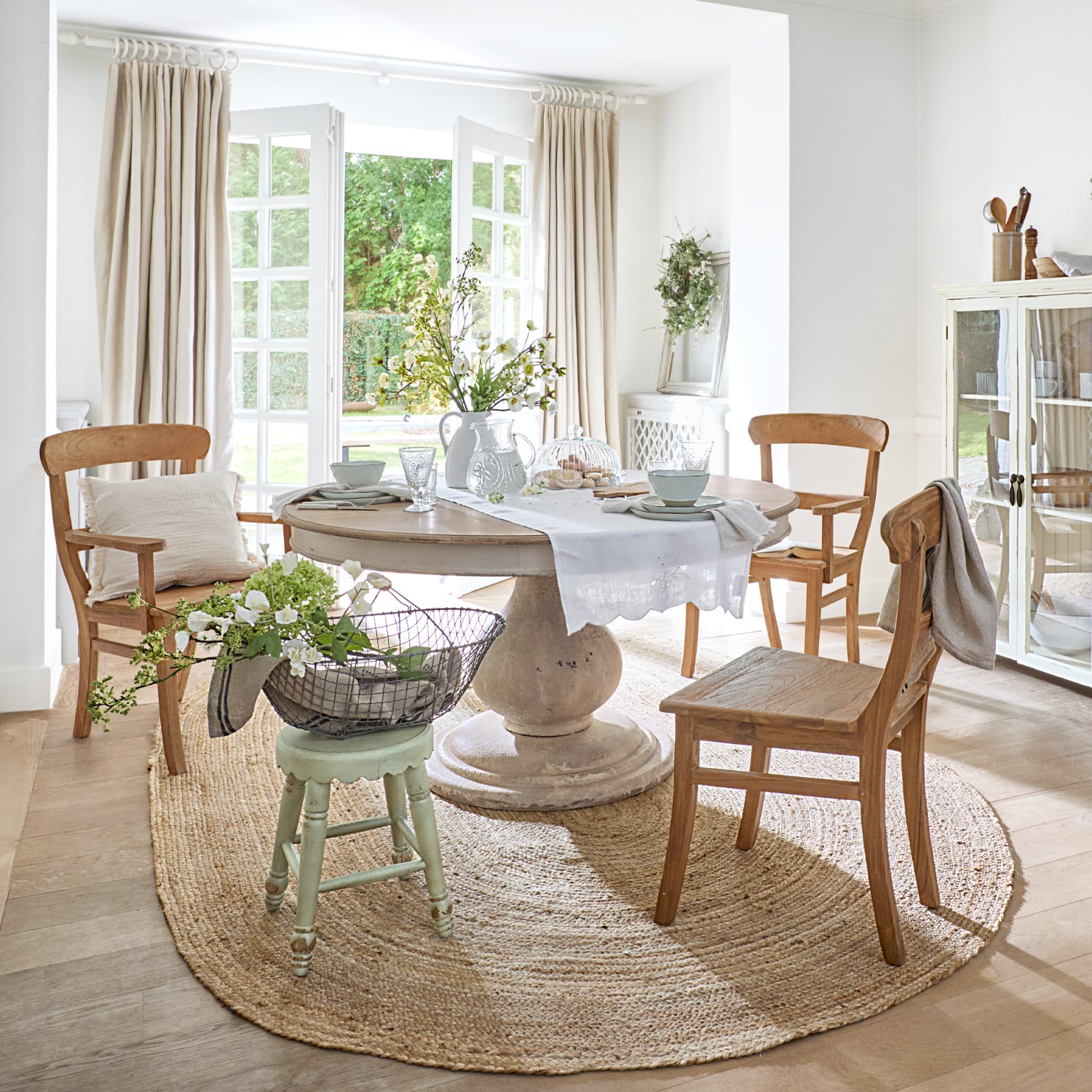 Esszimmer mit runder Steintisch und Holzstühlen auf rundem Jute-Teppich