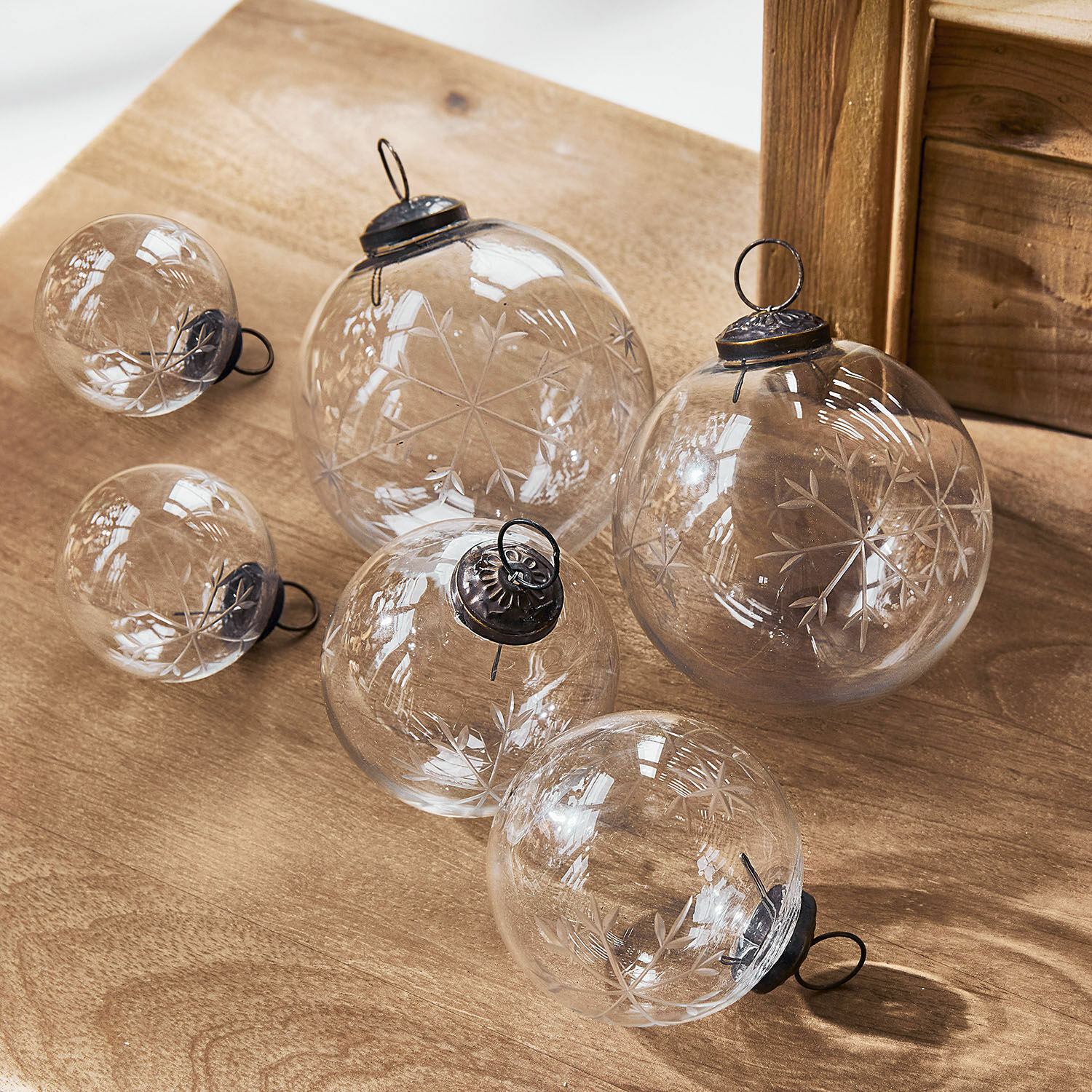 Weihnachtsschmuck 6er Set Coro Set aus transparenten Glas-Weihnachtskugeln mit graviertem Schneeflockenmuster auf Holzuntergrund