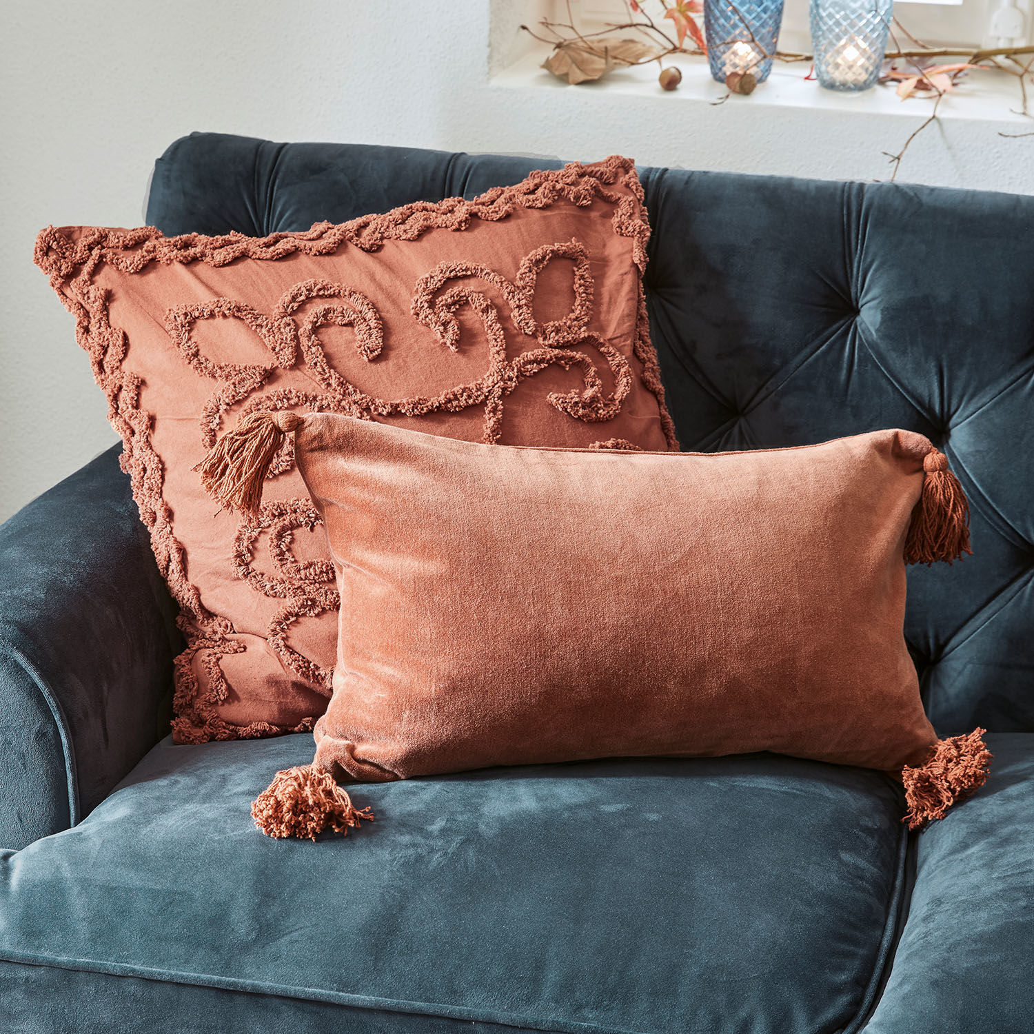 Kissenhülle 2er Set Posadas Zwei dekorative Kissen aus orangefarbenem Samt auf dunkelblauem Sofa, weiche und stilvolle Wohnaccessoires