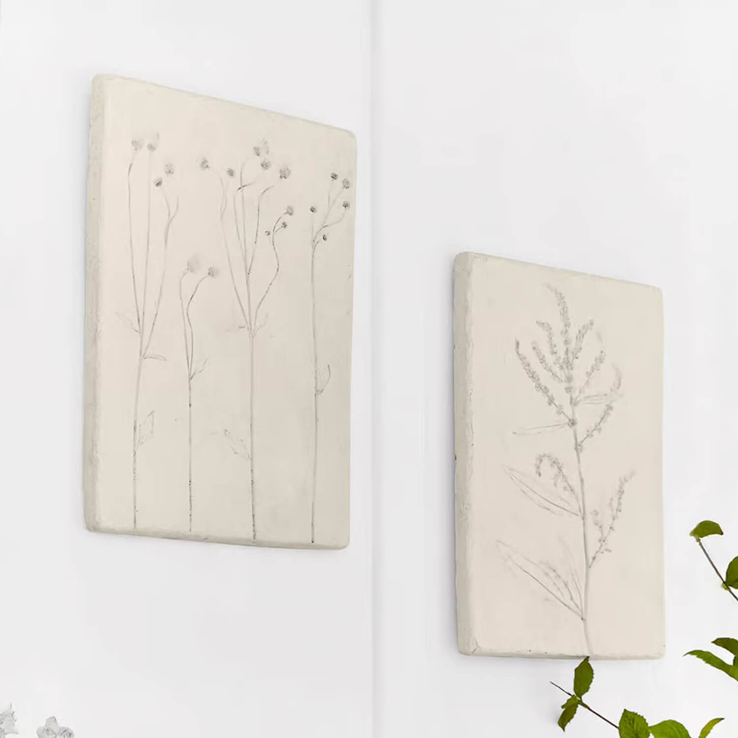 Zwei weiße Wandtafeln mit zarten Pflanzenmotiven als natürliche Wanddekoration