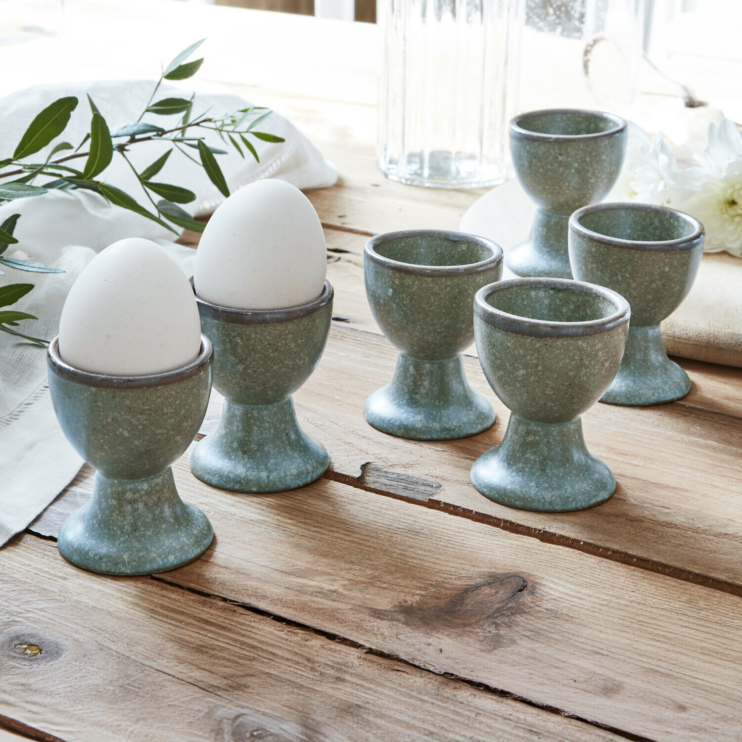 Eierbecher 6er Set Biarré Set aus sechs grünen Keramik-Eierbechern auf Holztisch für die Küche