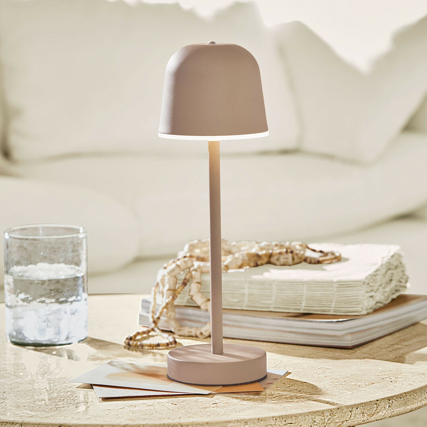 Wiederaufladbare Tischlampe Ulianne Beige Metall-Tischlampe mit minimalistischem Lampenschirm auf hellem Hintergrund im Wohnzimmer