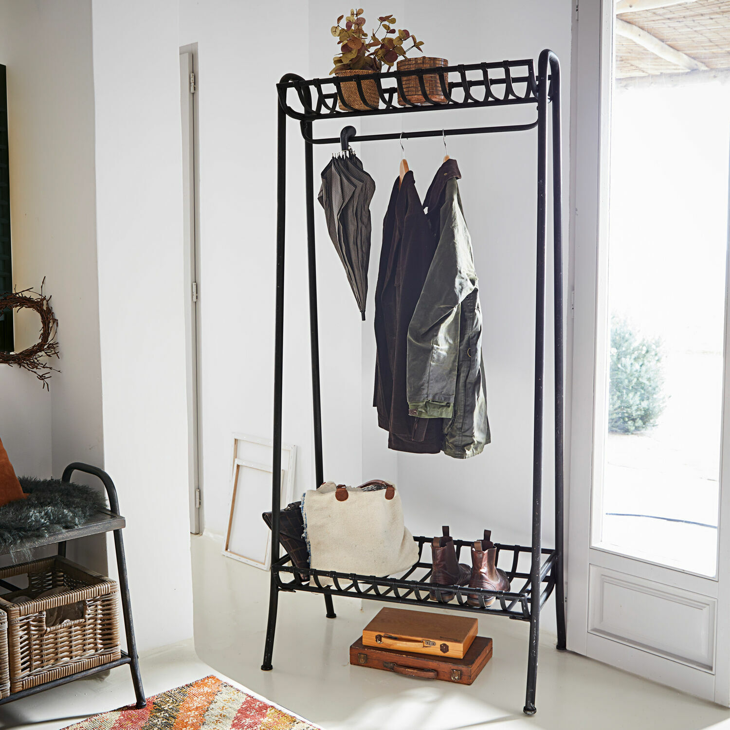 Garderobe Downey Schwarzer Metall-Garderobenständer mit Ablagen für Schuhe und Accessoires in hellem Raum
