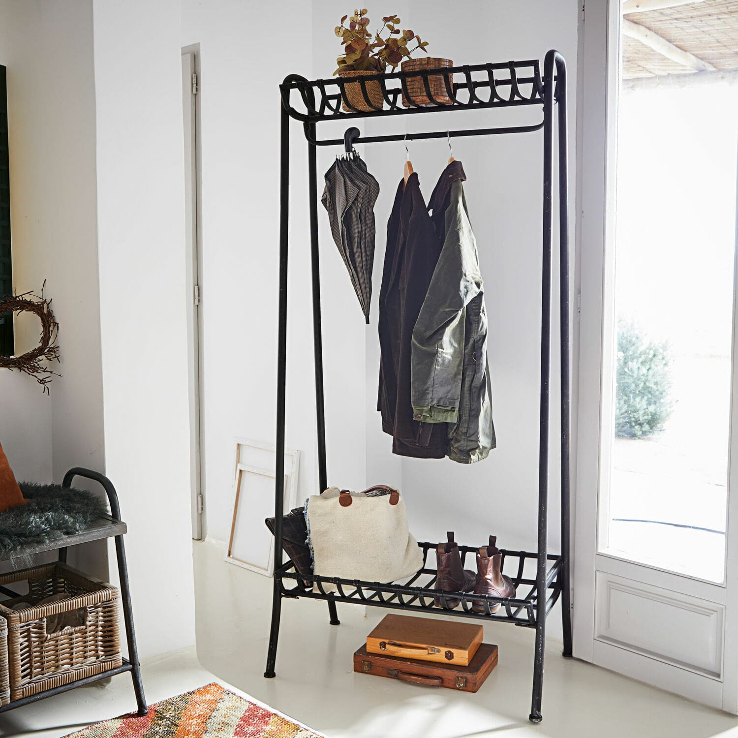 Garderobe Downey Schwarzer Metall-Garderobenständer mit Ablagen für Schuhe und Accessoires in hellem Raum