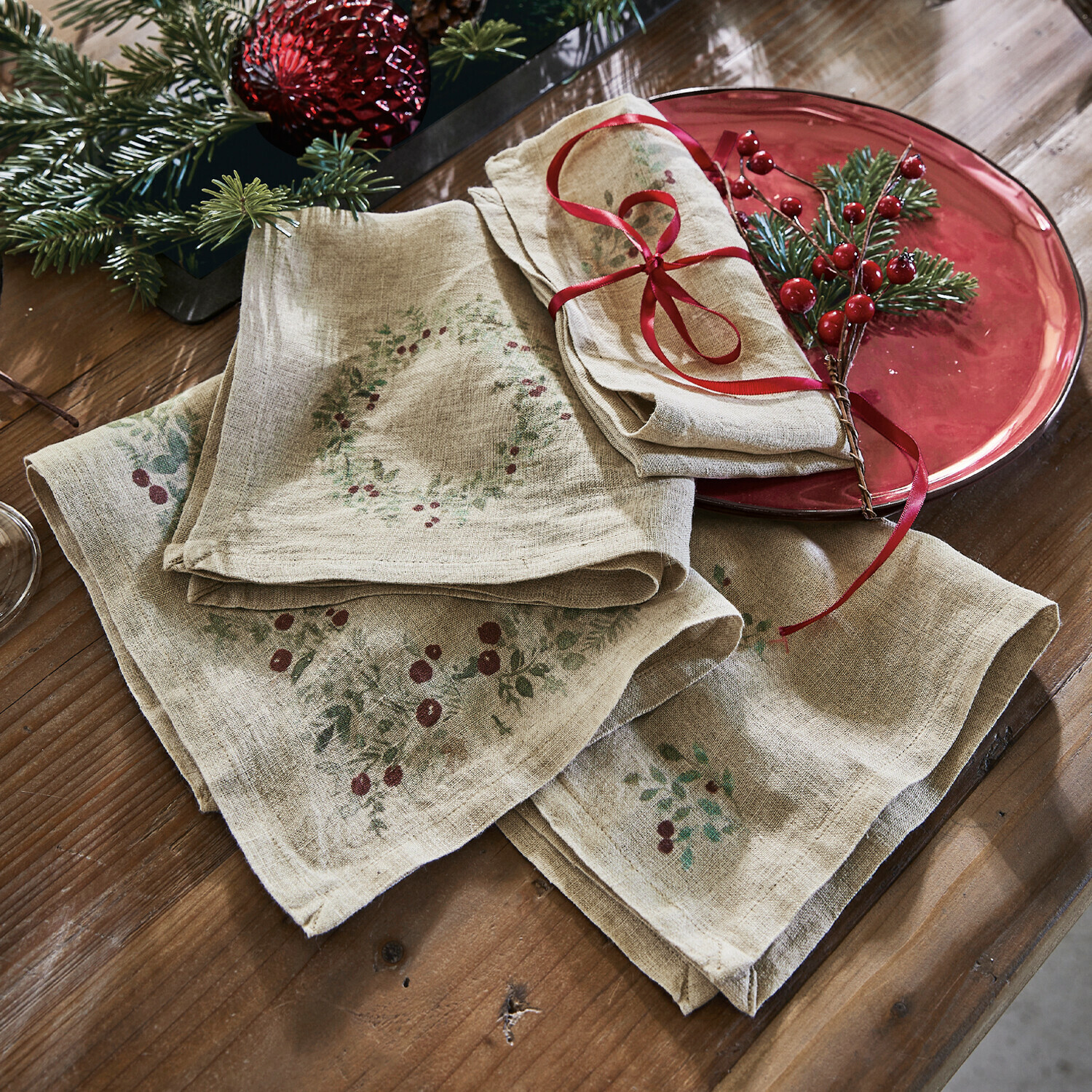 Serviette 4er Set Lenius Leinenservietten mit rotem Beerenmuster auf Holztisch, festliche Weihnachtsdekoration