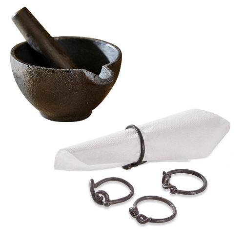 Schwarzer Gusseisen-Mörser mit Stößel und schwarzen Metall-Serviettenringen für die Küche