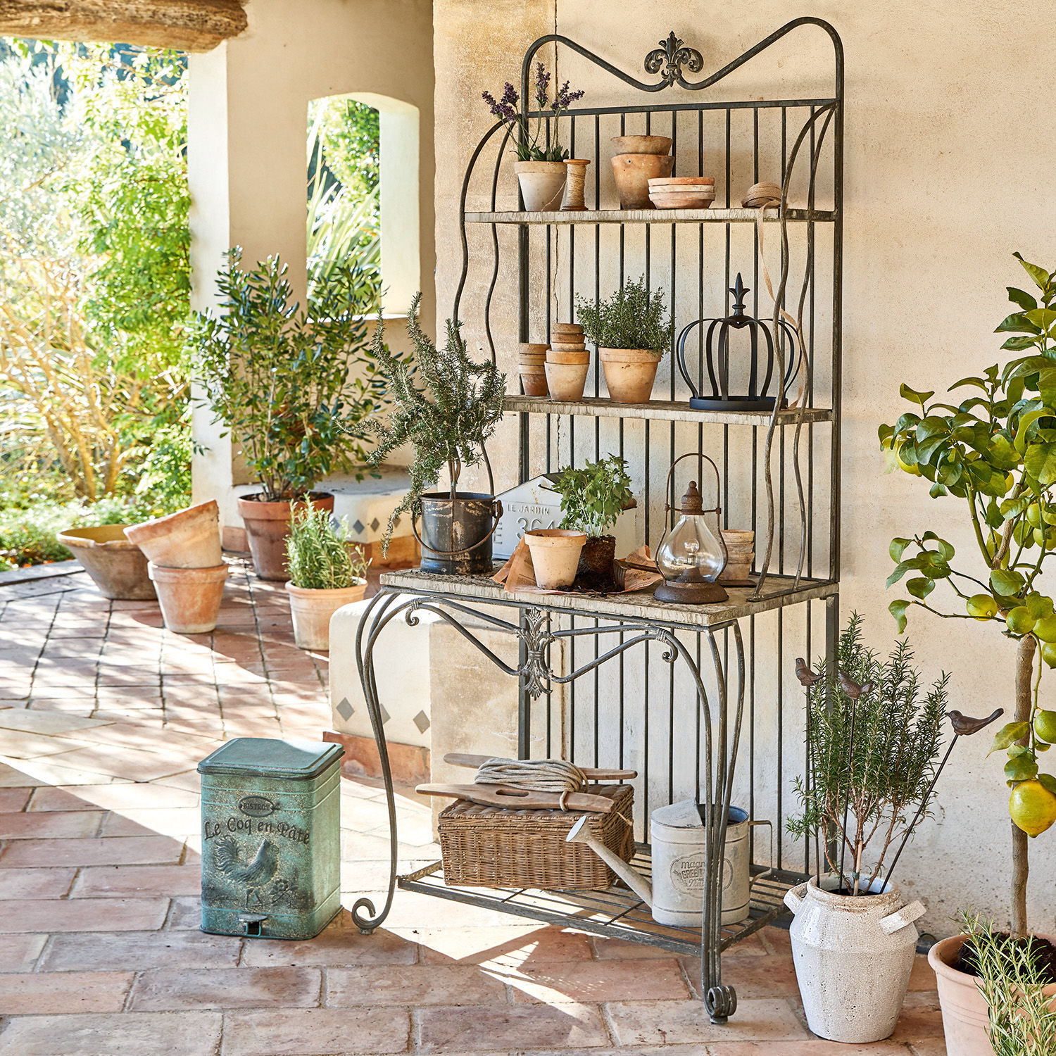 Regal Rentlor Metall-Gartenschrank mit Regalen und Terrakottatöpfen auf rustikalem Ziegelterrassenboden