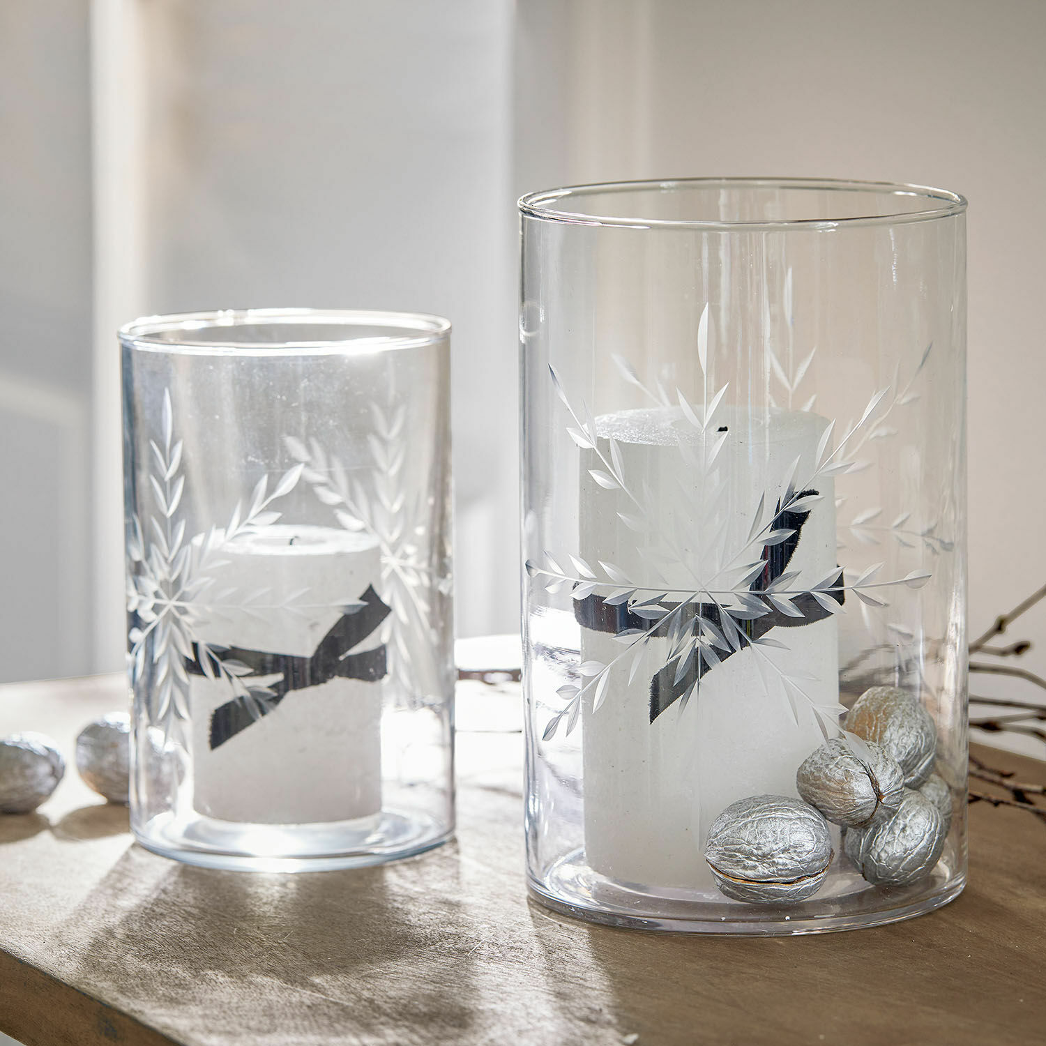 Windlicht 2er Set Snowflakes Glaswindlichter mit weißen Kerzen und silbernen Nüssen auf Holztisch, festliche Dekoration