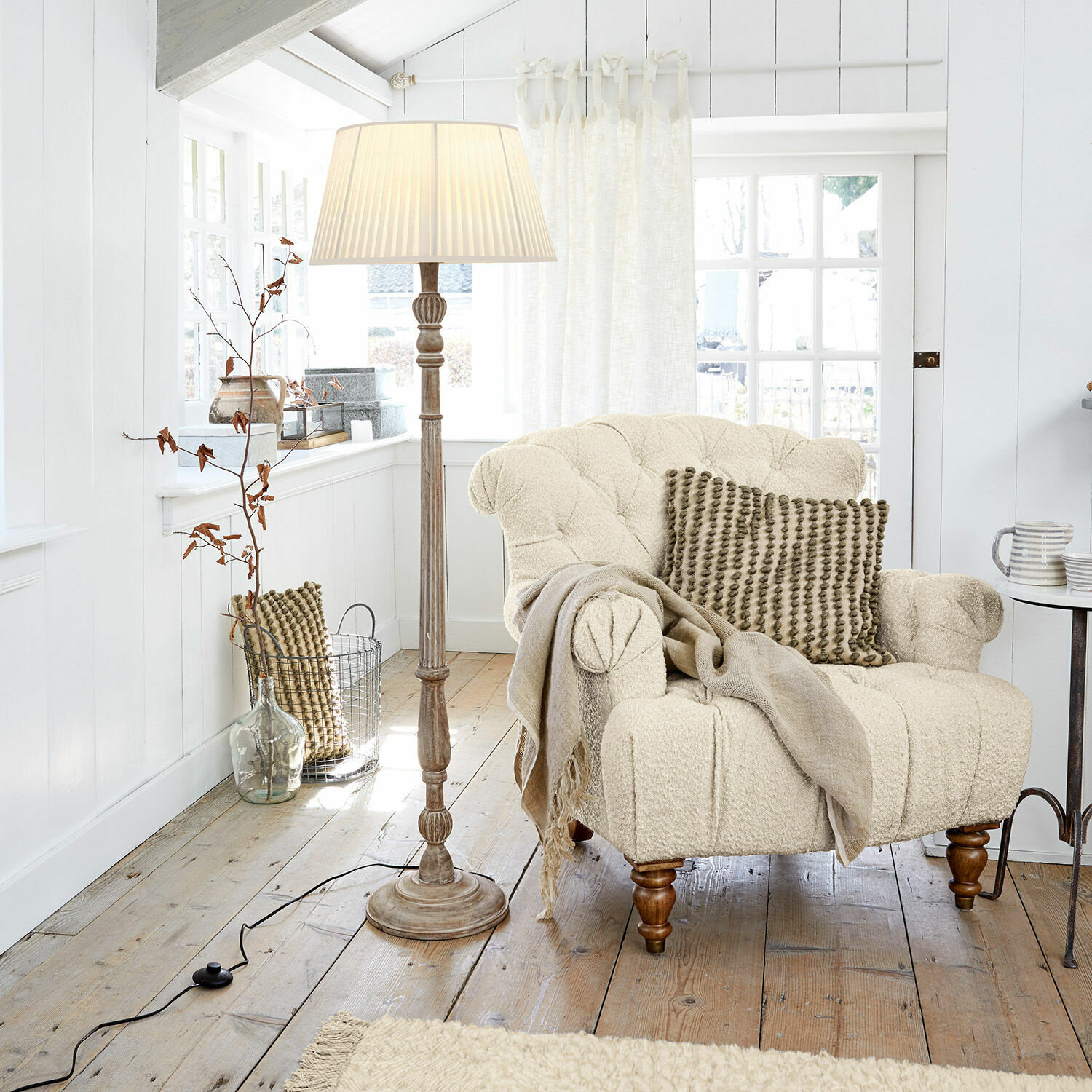Stehlampe Morten Beiger Bouclé-Sessel mit Kissen und Stehlampe in hellem Holzwohnzimmer