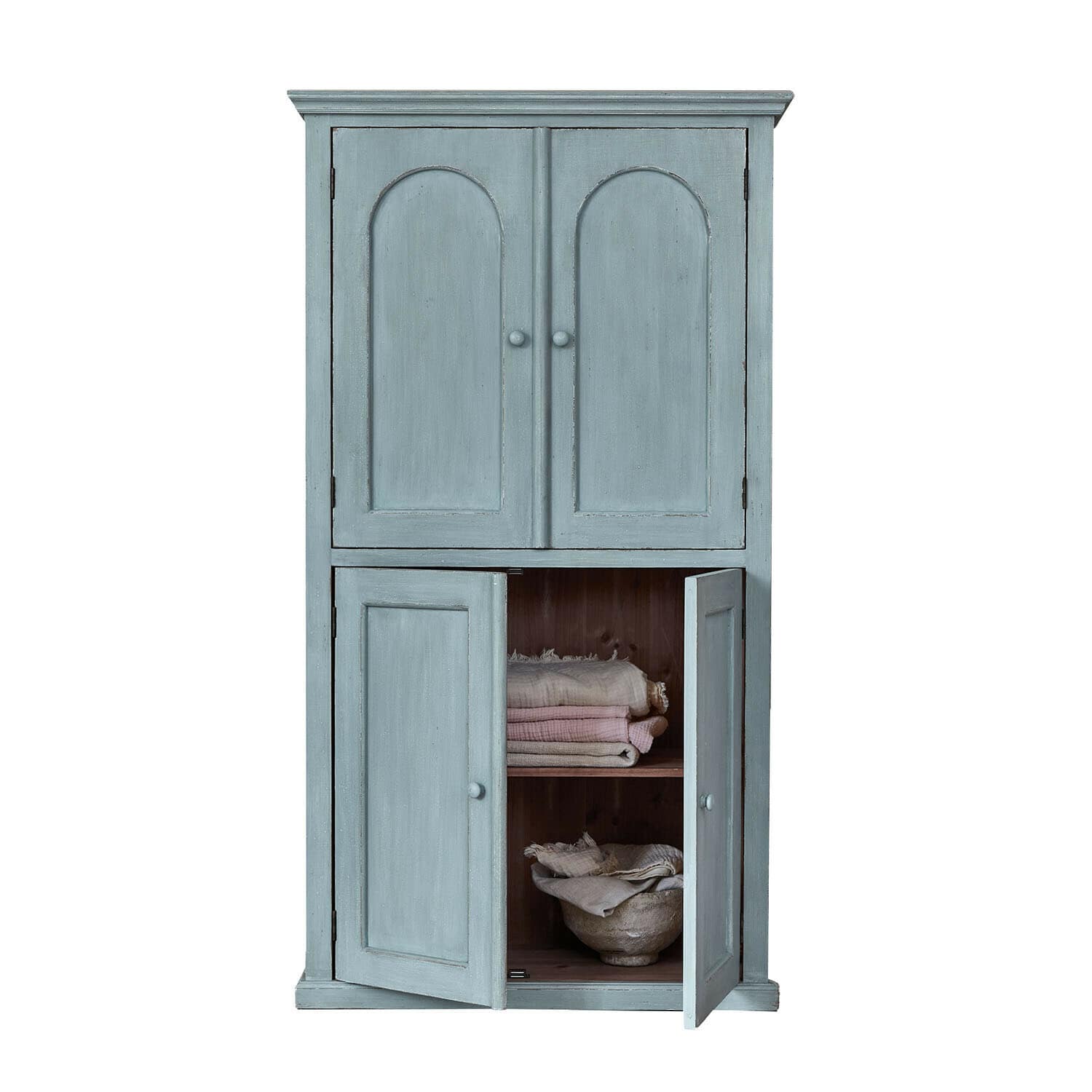 Blauer Holzschrank mit zwei geschlossenen und zwei offenen Türen, gefüllt mit Stoffen und einer Schale