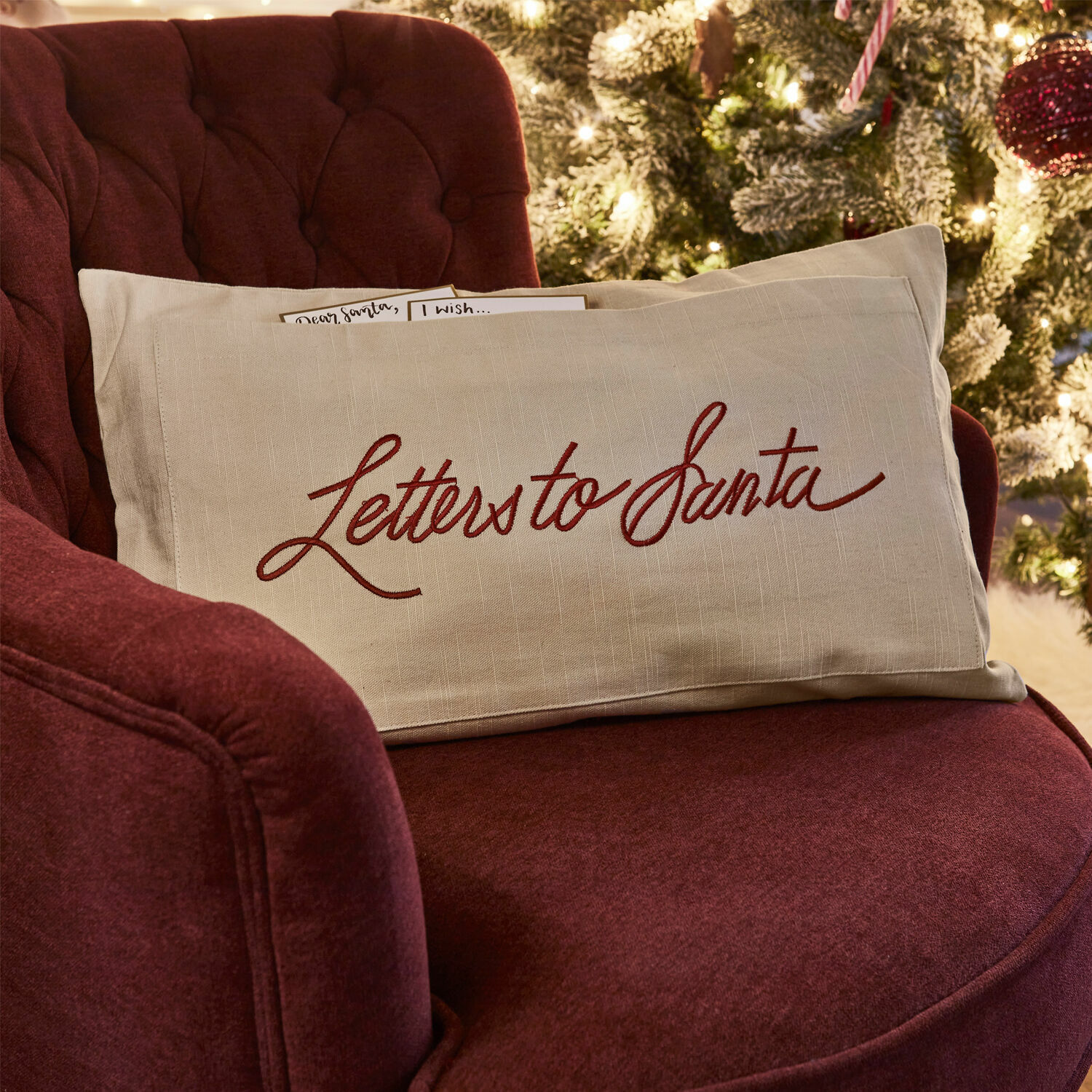 Kissenhülle Welenzas Beiges Leinenkissen mit rotem Schriftzug Letters to Santa auf bordeauxrotem Sessel vor Weihnachtsbaum
