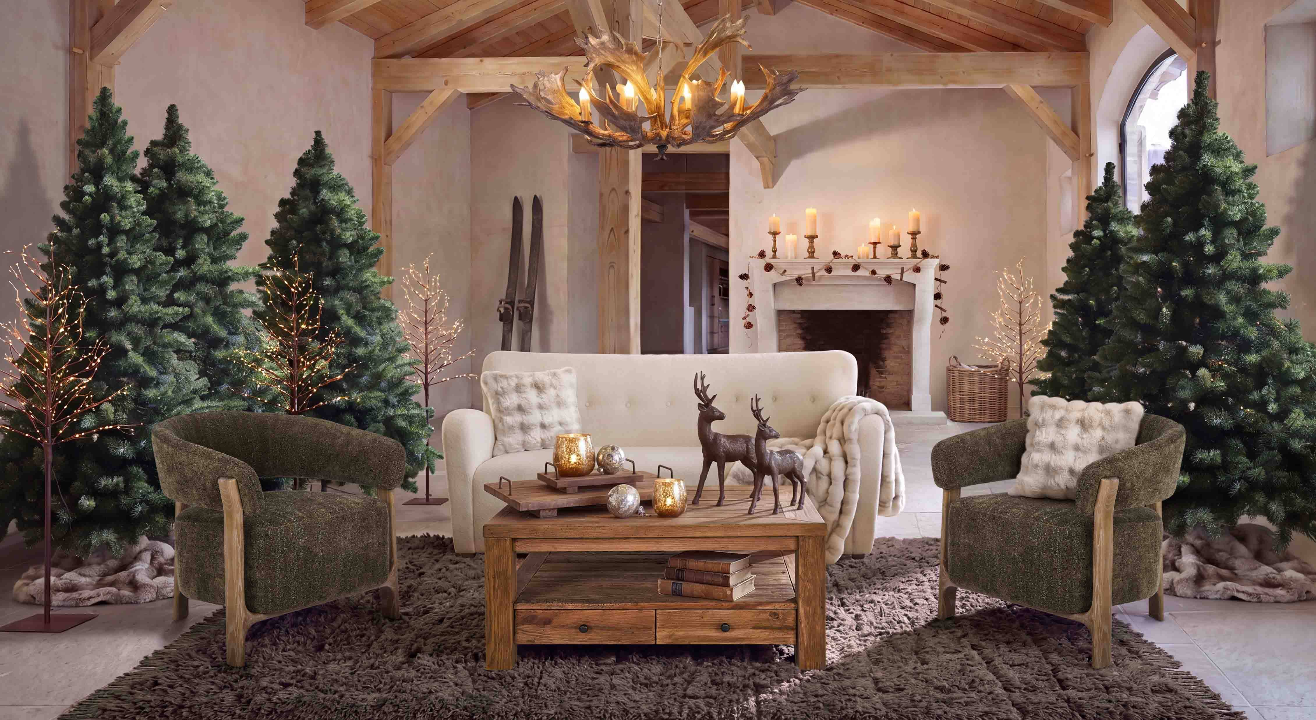Gemütliches Wohnzimmer mit weißem Sofa, grünen Sesseln und rustikalem Holztisch im Landhausstil