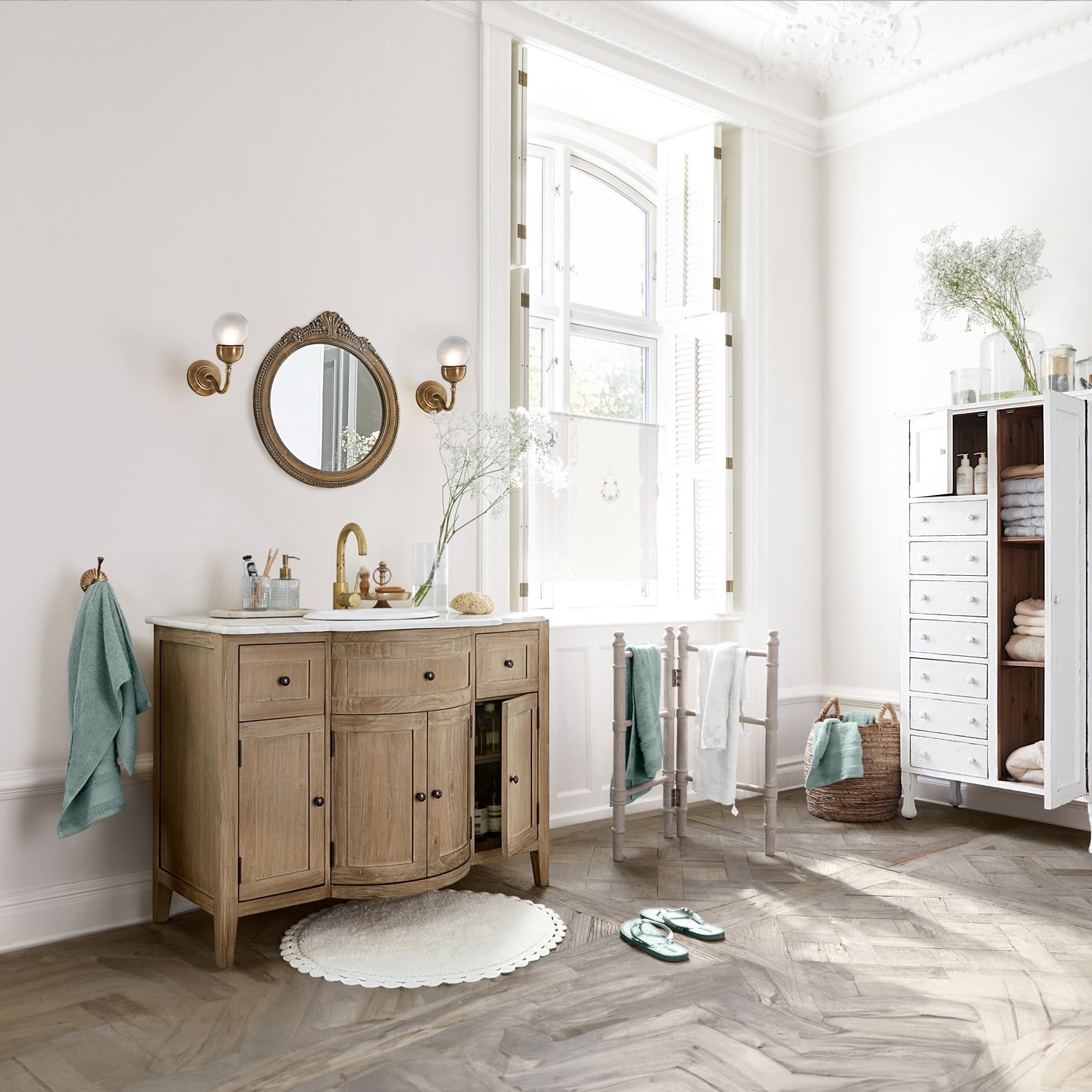 Badezimmer mit Holzwaschbeckenunterschrank, weißem Spiegel und weichen Handtüchern in Pastellfarben