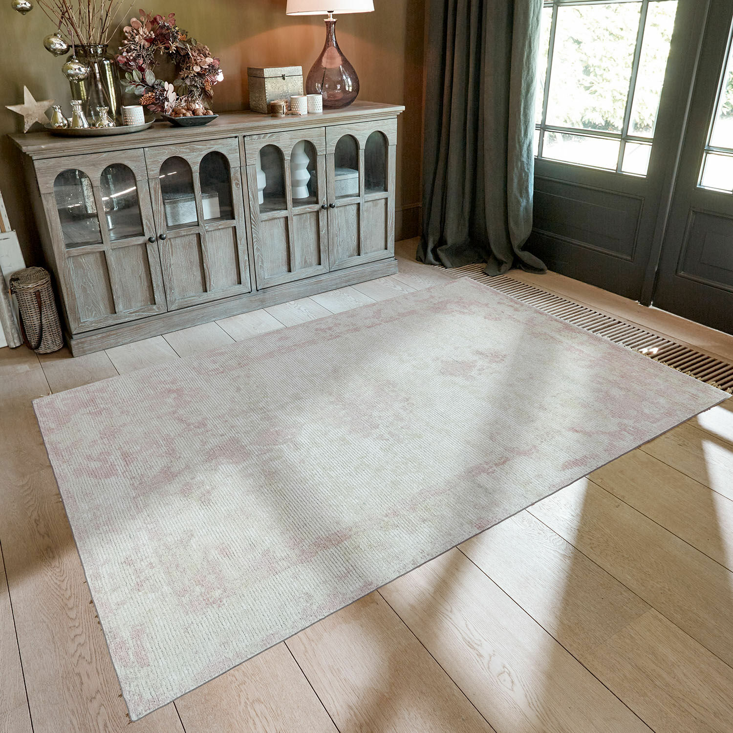 Beiger Teppich mit zartrosa Mustern auf Holzboden in stilvollem Raum