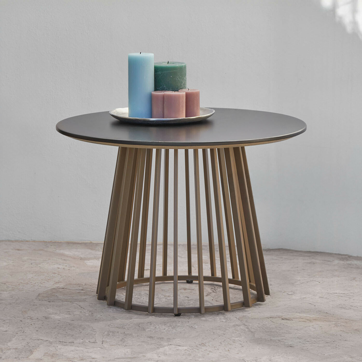 Runder Couchtisch mit schwarzer Metallplatte und brauner Stab-Unterkonstruktion, dekoriert mit Kerzen